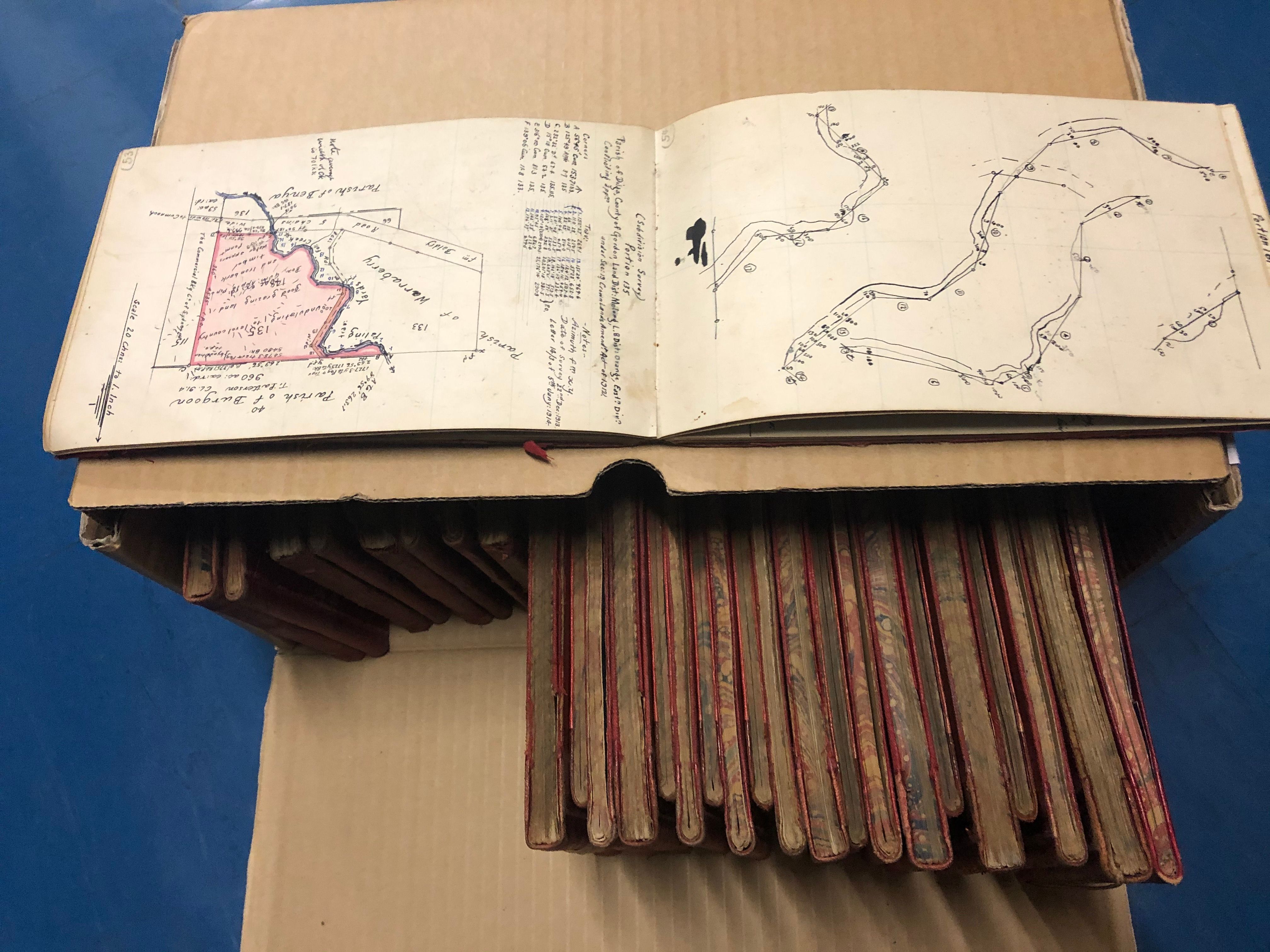 A sketch book by a surveyor sits on top of the box it is stored in