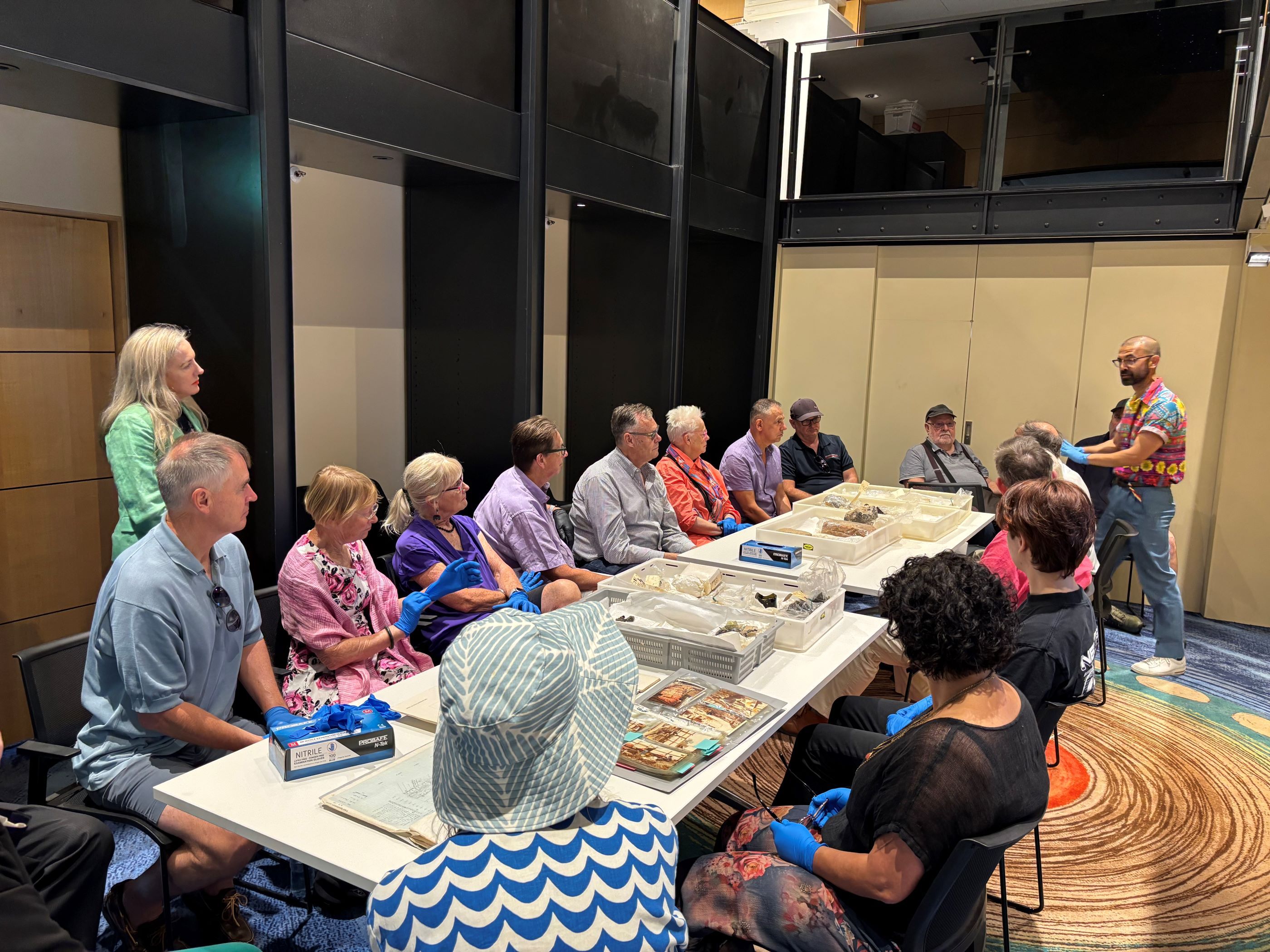 Dr Aaron De Souza (standing, right), Research Manager at Museums of History NSW, presenting archaeological artefacts from the site of Australia’s first Government House