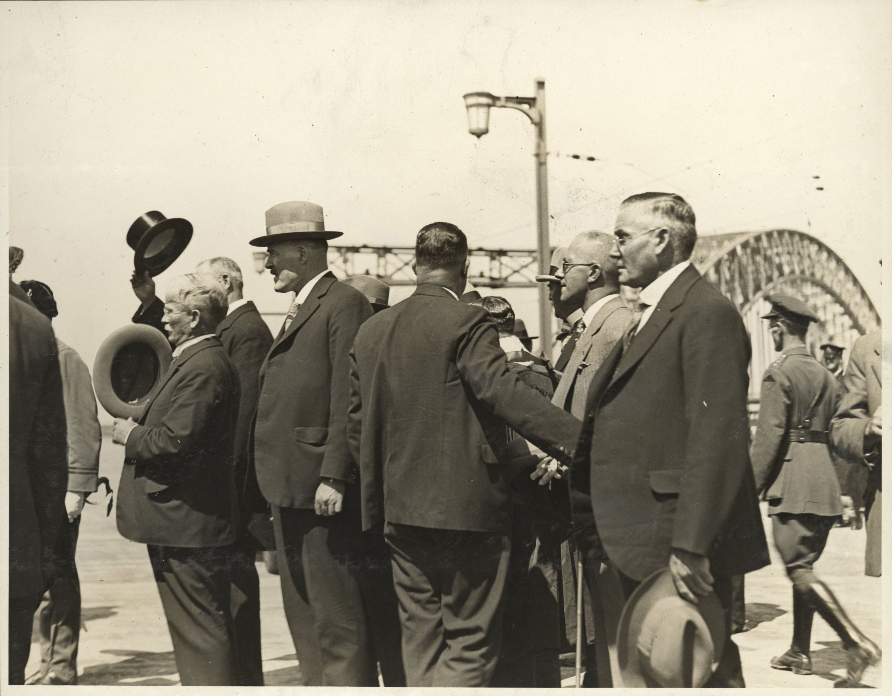 A group of men stand with the Sydney Harbour Bridge in the background