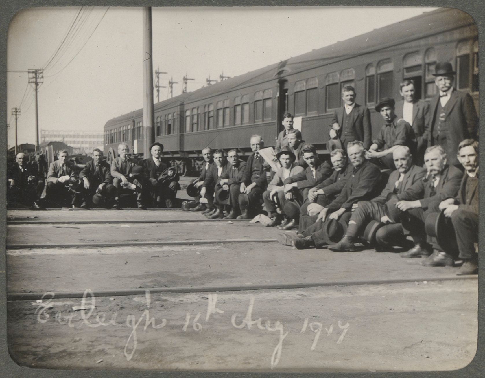 Men crouch in front of a train carriage at the Eveleigh Workshops in 1917