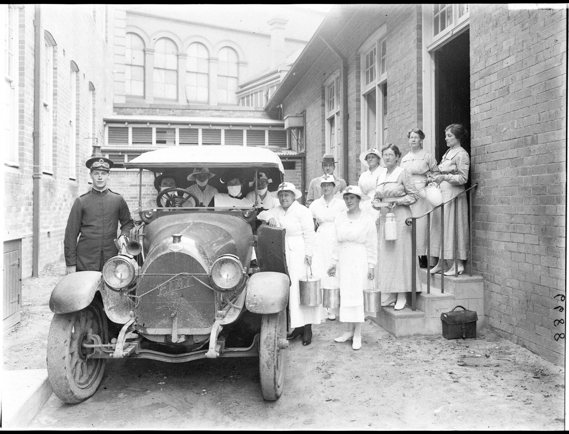 Medical staff pose next to a car