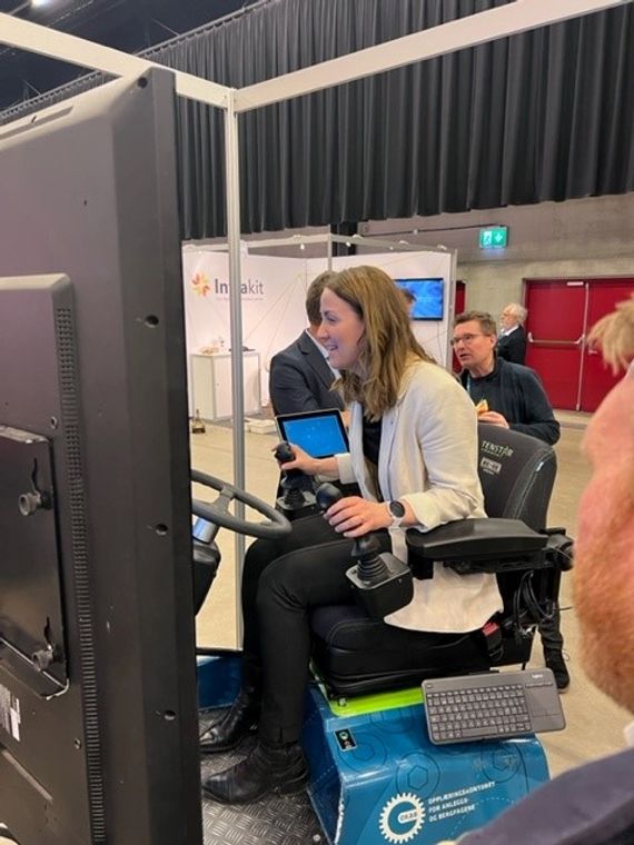 Kunnskapsminister Tonje Brenna kjører gravemaskinsimulator. 