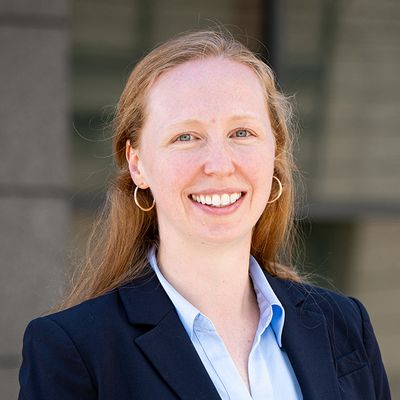 Erica Twardzik, wearing a navy blazer, faces towards the camera