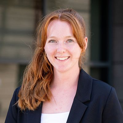Christina Kiser, wearing a black blazer, faces the towards the camera