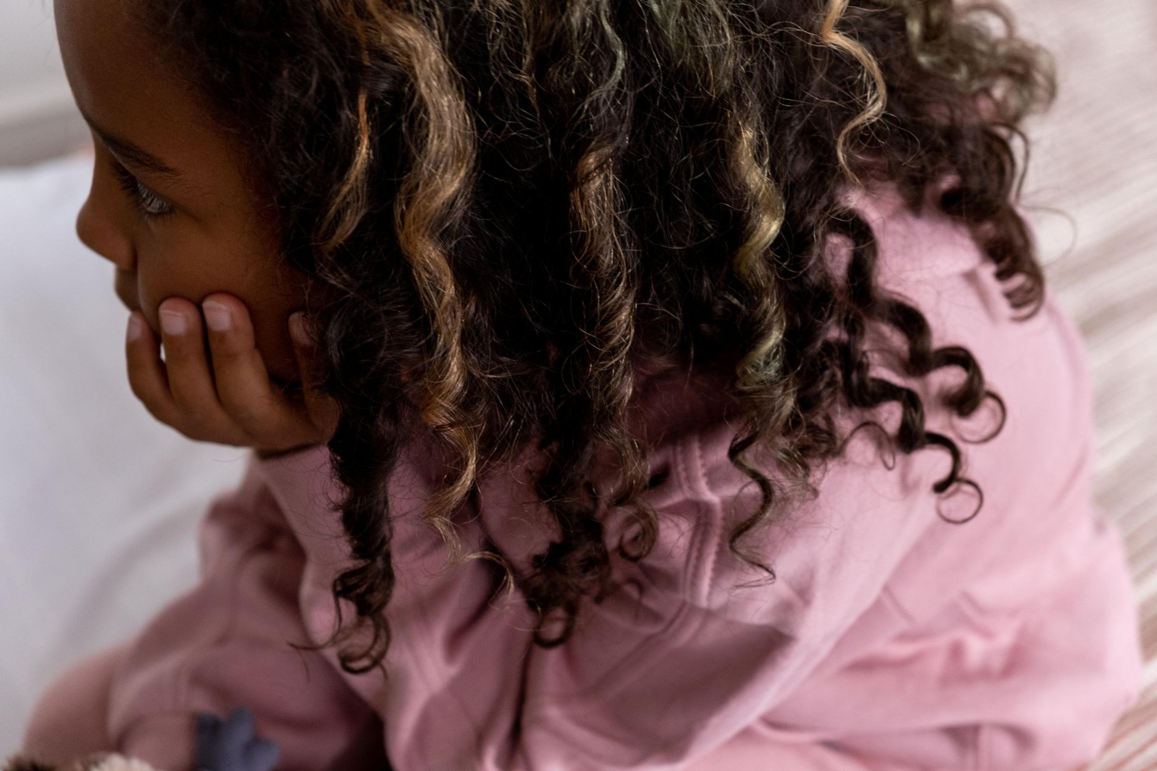Close-up of a child's soft, defined natural curls after applying curl defining jelly, showing shiny ringlets without crunch