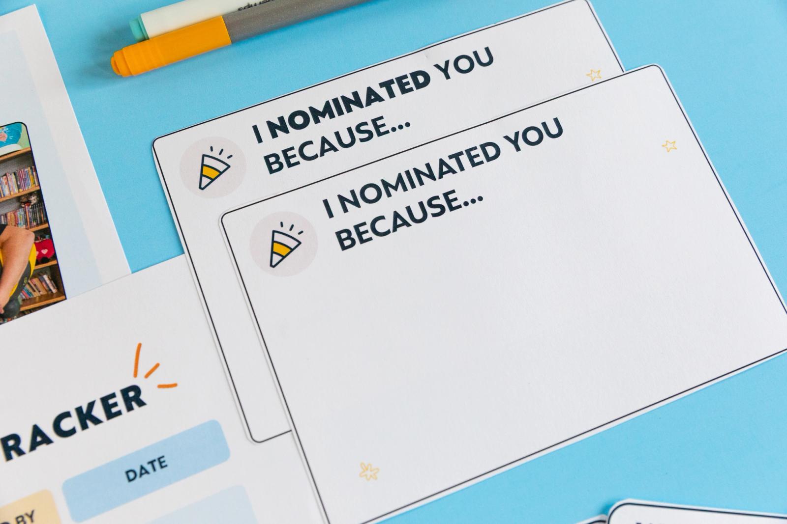 Closeup of notecards that say "I nominated you because..." laying on a light blue background.