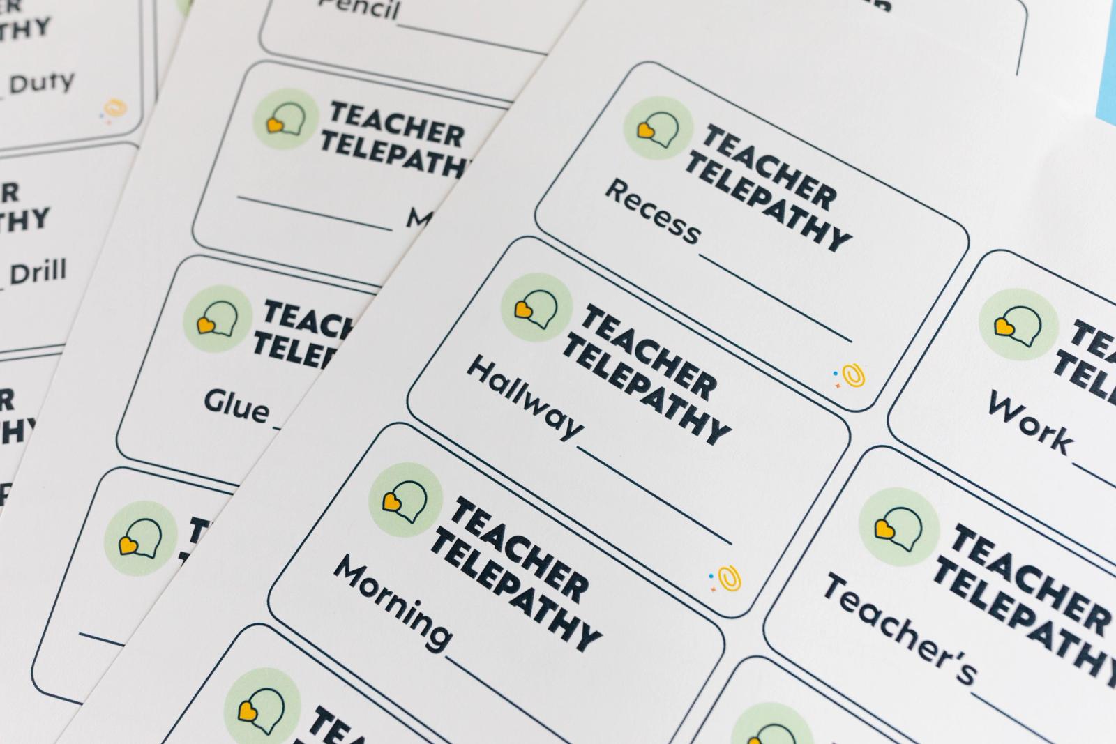 Close-up of sheets of paper that has multiple cards on it, each saying "teacher telepathy."