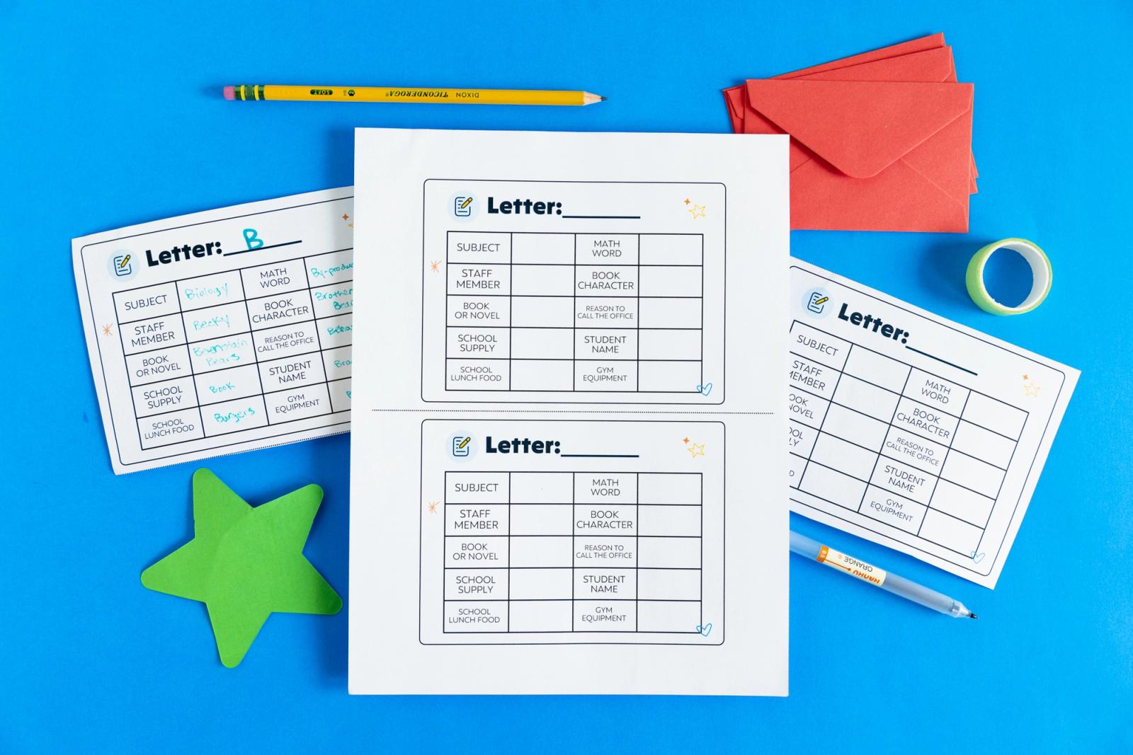 Sheets of paper, star cutouts, pencil, and envelopes lay on a blue background.