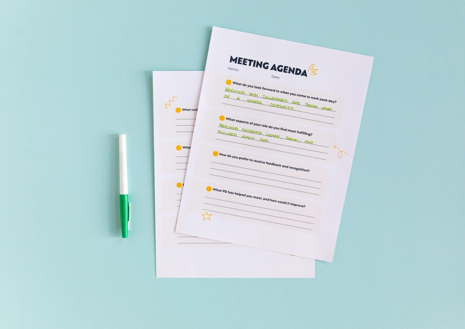 Two pieces of paper with handwriting on them lay on a light blue background with a green pen on the side.