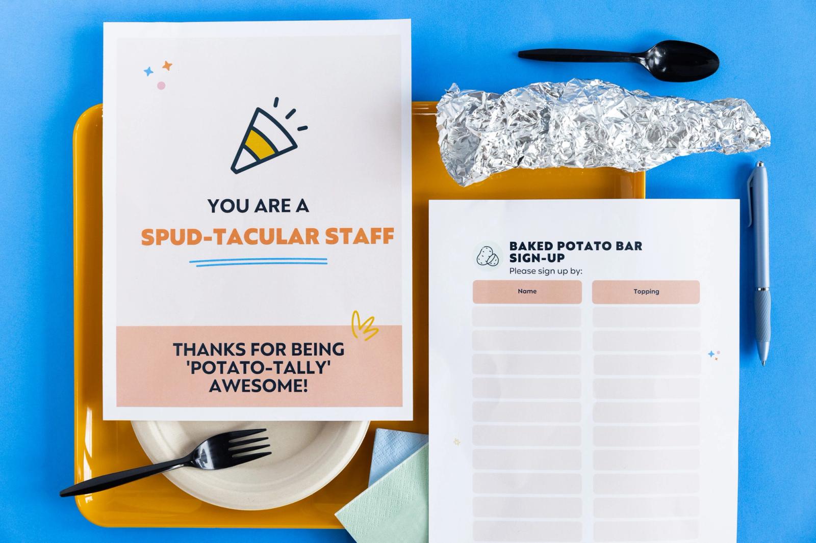 An orange tray with a paper plate, fork, and tin foil lays on a blue background. Two sheets of paper lay on top of the tray.