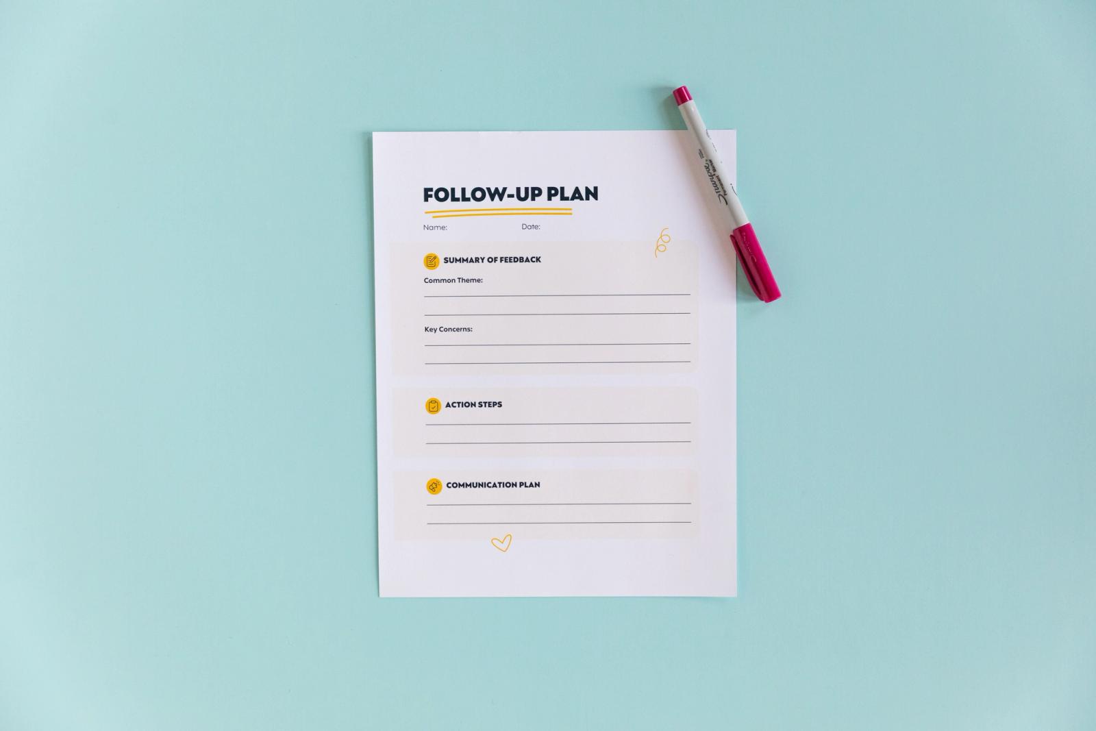A sheet of paper with "follow up plan" typed on it lays on a light blue background with a red pen on the side.