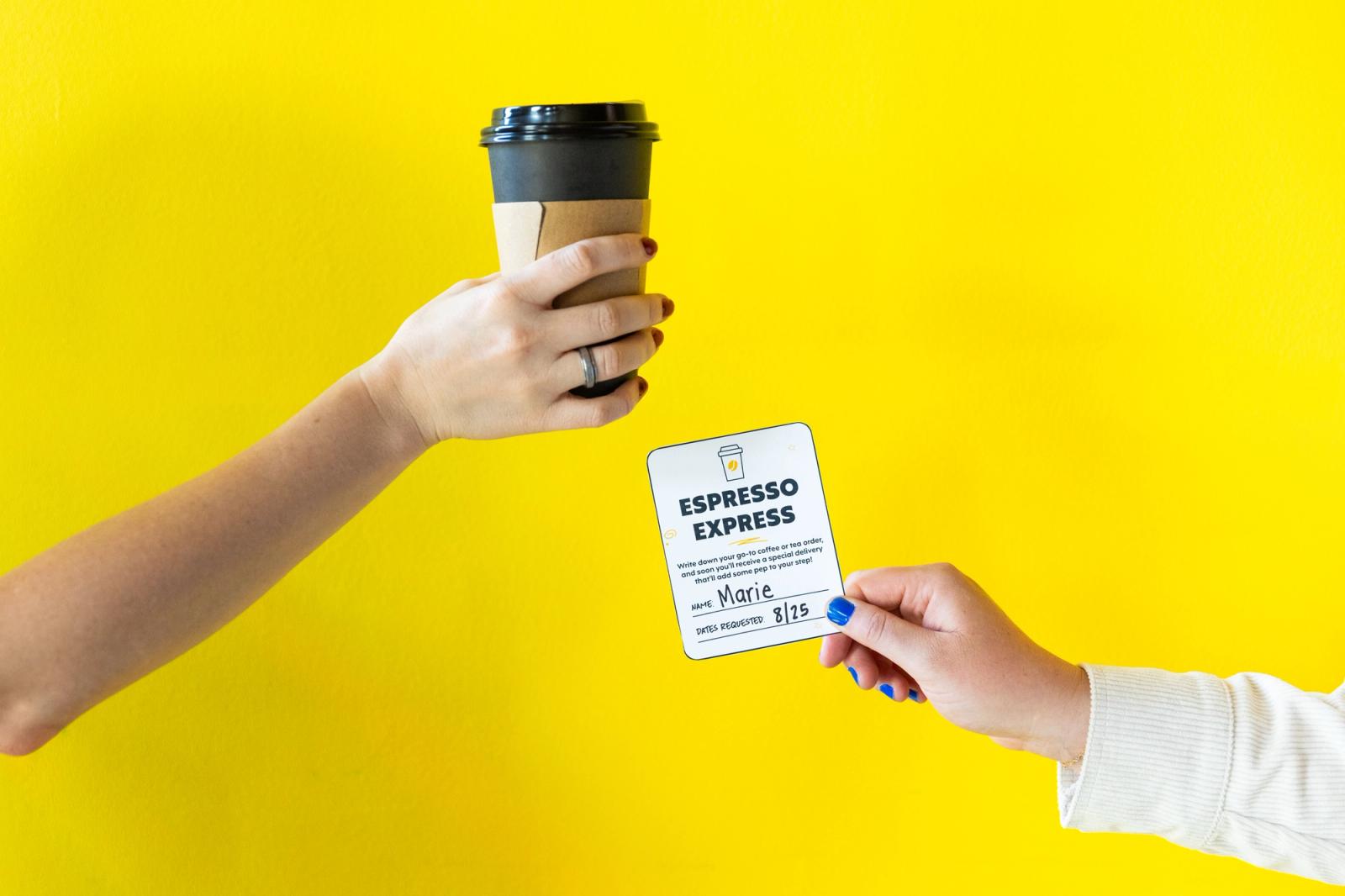 A hand holding a to-go coffee cup reaches in from the left. A hand holding a small paper coupon reaches in from the right, in front of a yellow background.
