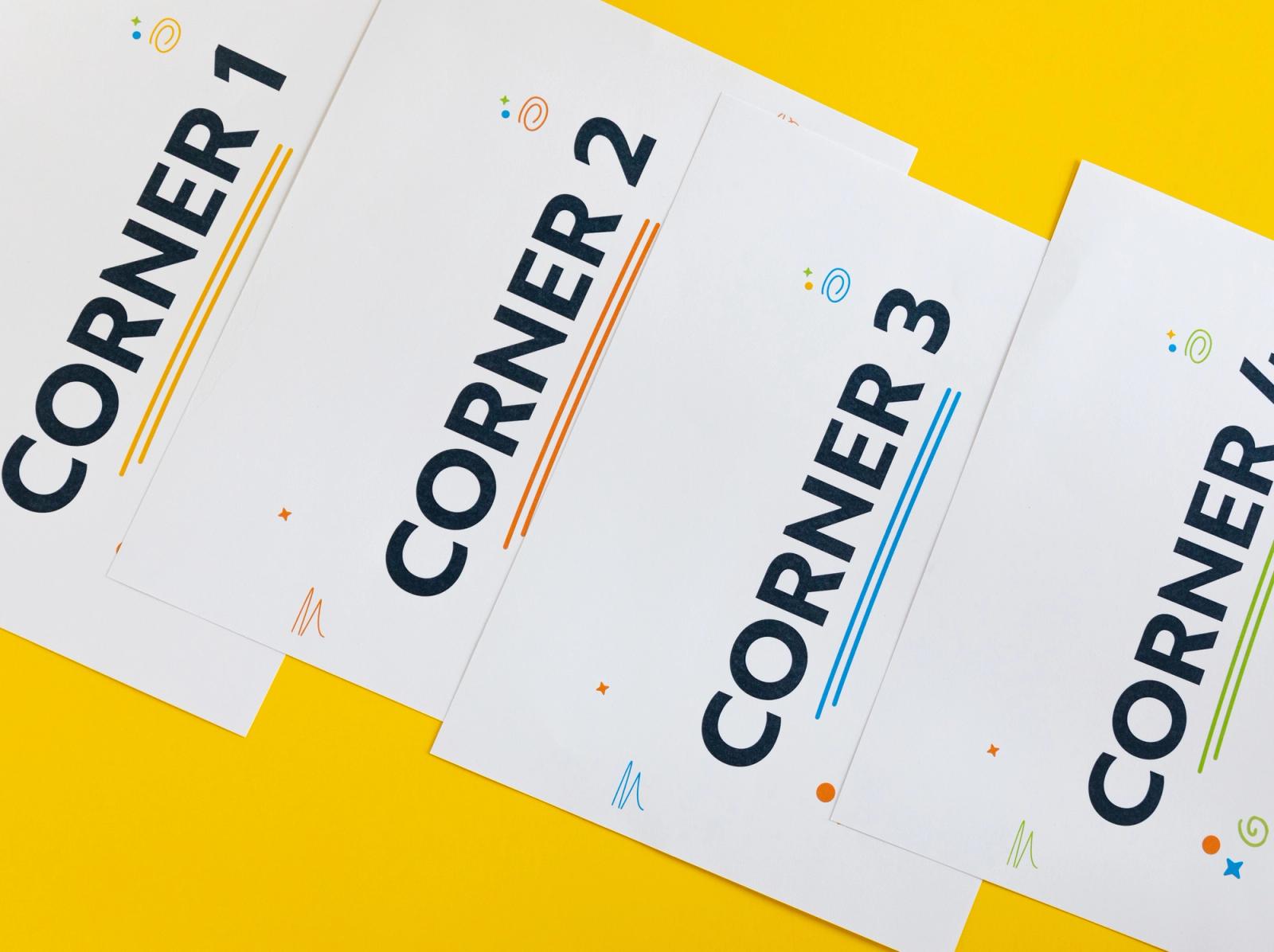 Close up of four sheers of paper labeled as corner 1, 2, 3, and 4 lay diagonally on a yellow background.