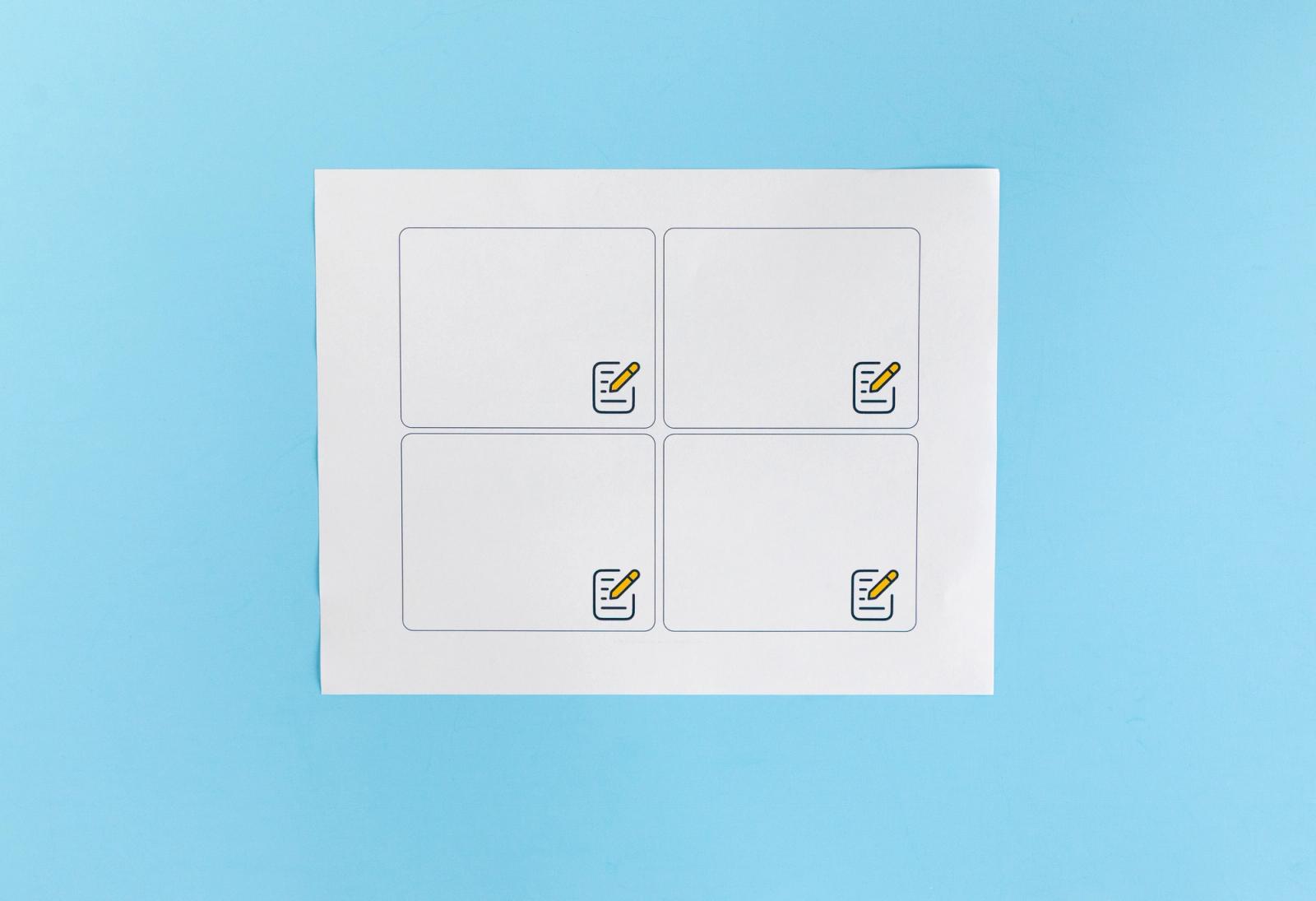 Sheet of paper with blank notecards lays on a light blue background.