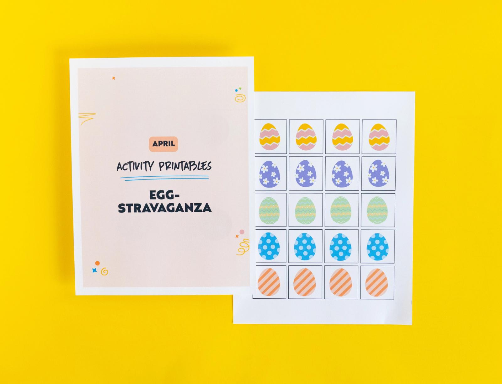 Paper that says "egg-stravaganza" and paper with small pictures of Easter eggs lay on a yellow background.