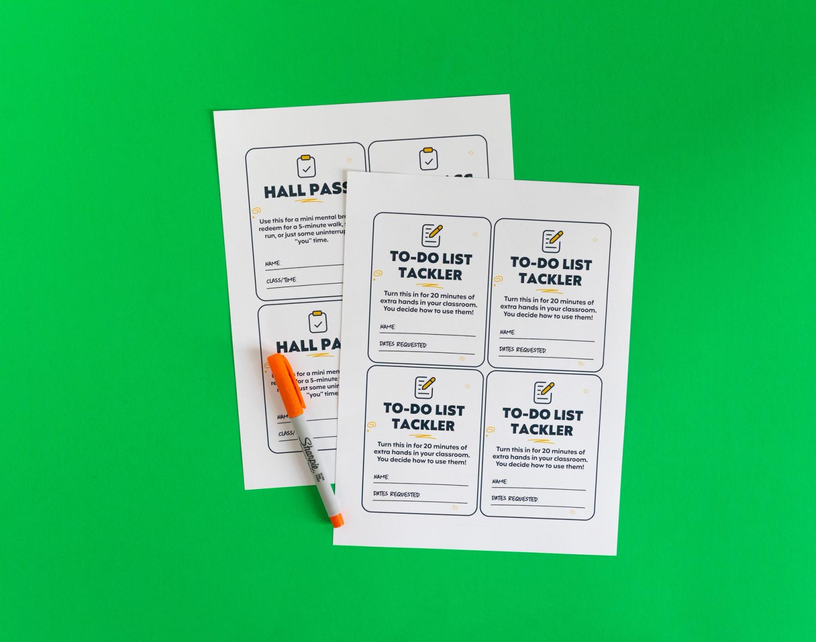 two sheets of paper with several coupons on them and an orange pen lays on a green background.
