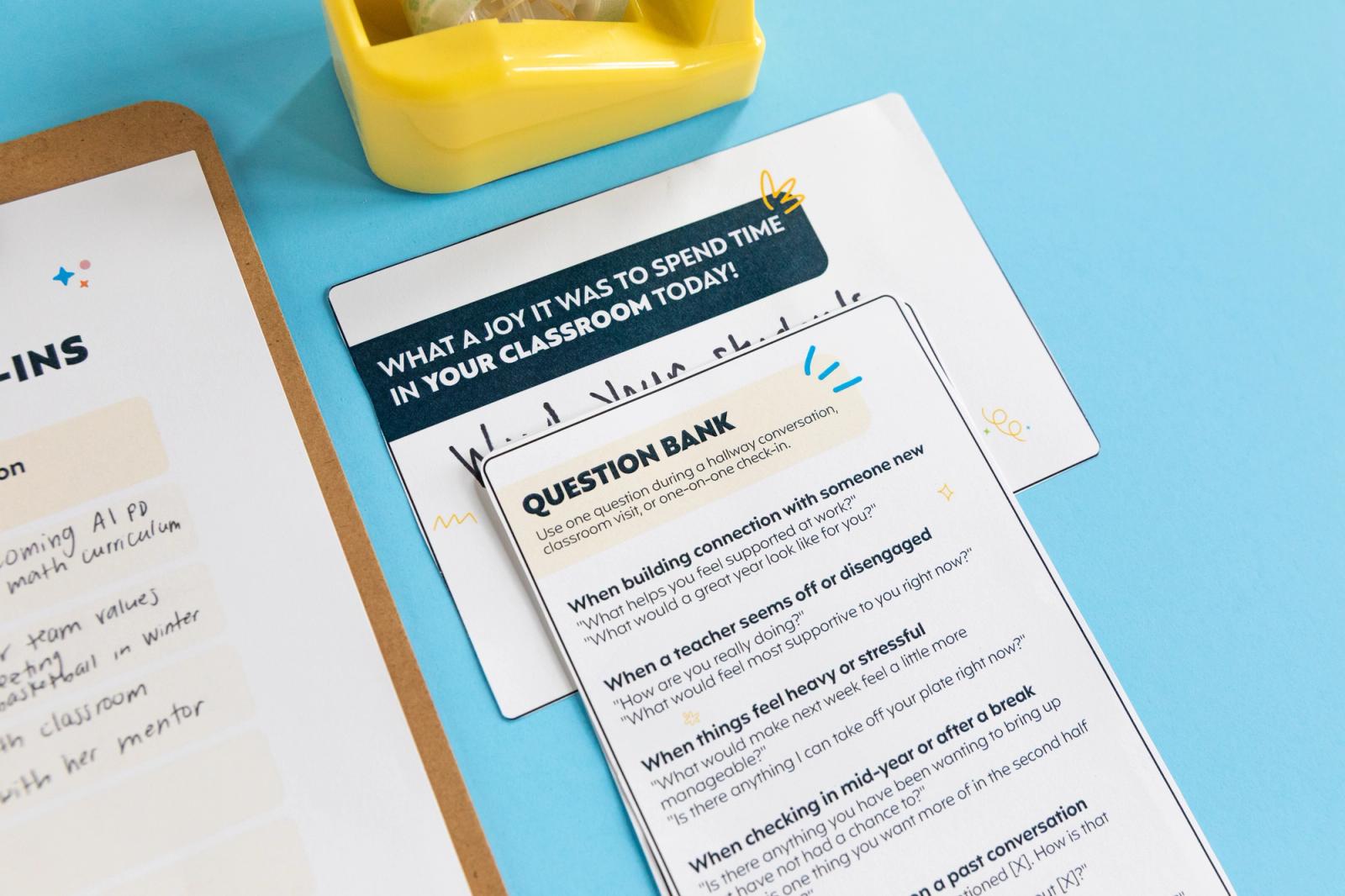 A card that says "question bank", notecard and part of a clipboard lays on a light blue background.