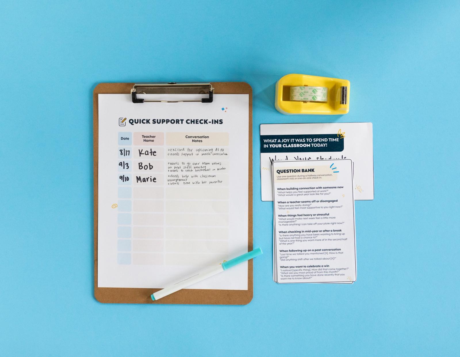 A sheet of paper on a clipboard and small pieces of paper lay on a light blue background with a tape dispenser and marker.
