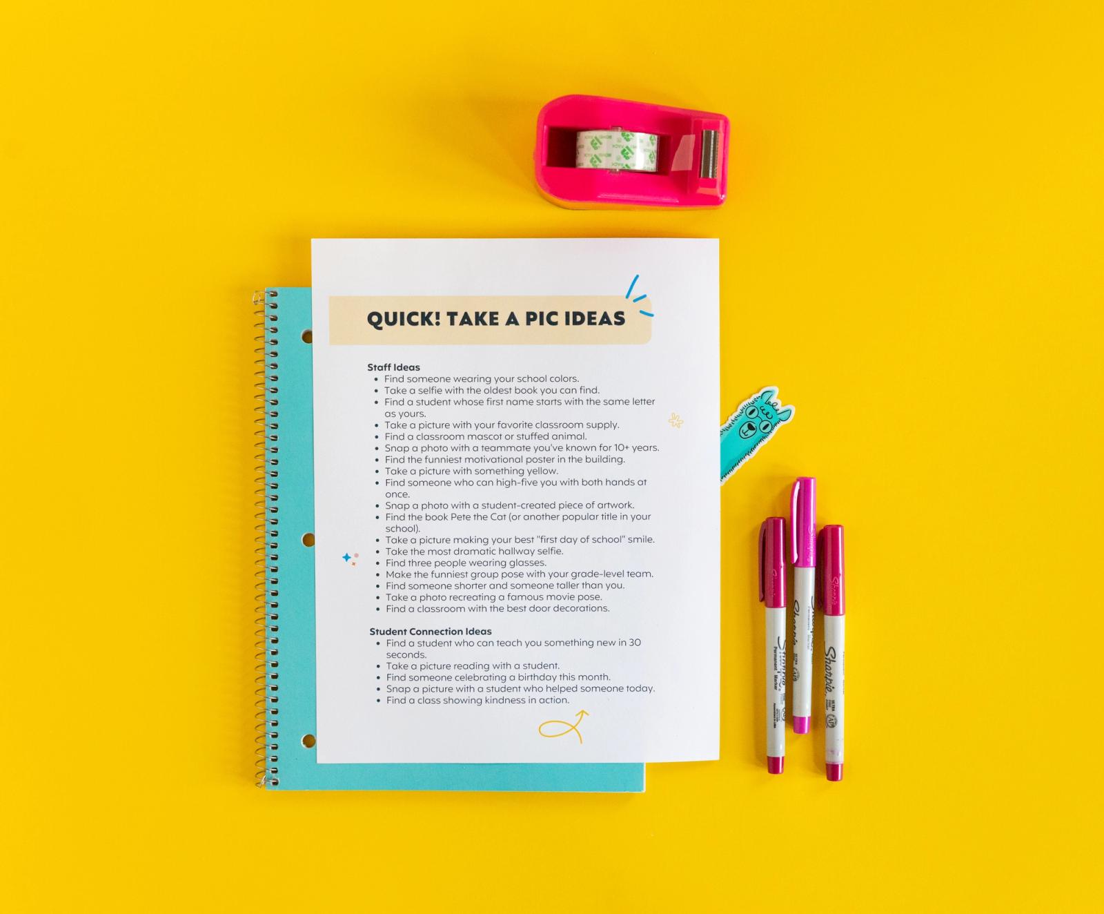 A paper lays on a blue notebook on a yellow background. Pens and a tape dispenser lay around the paper. A blue alpaca sticker peeks out from behind the paper. 