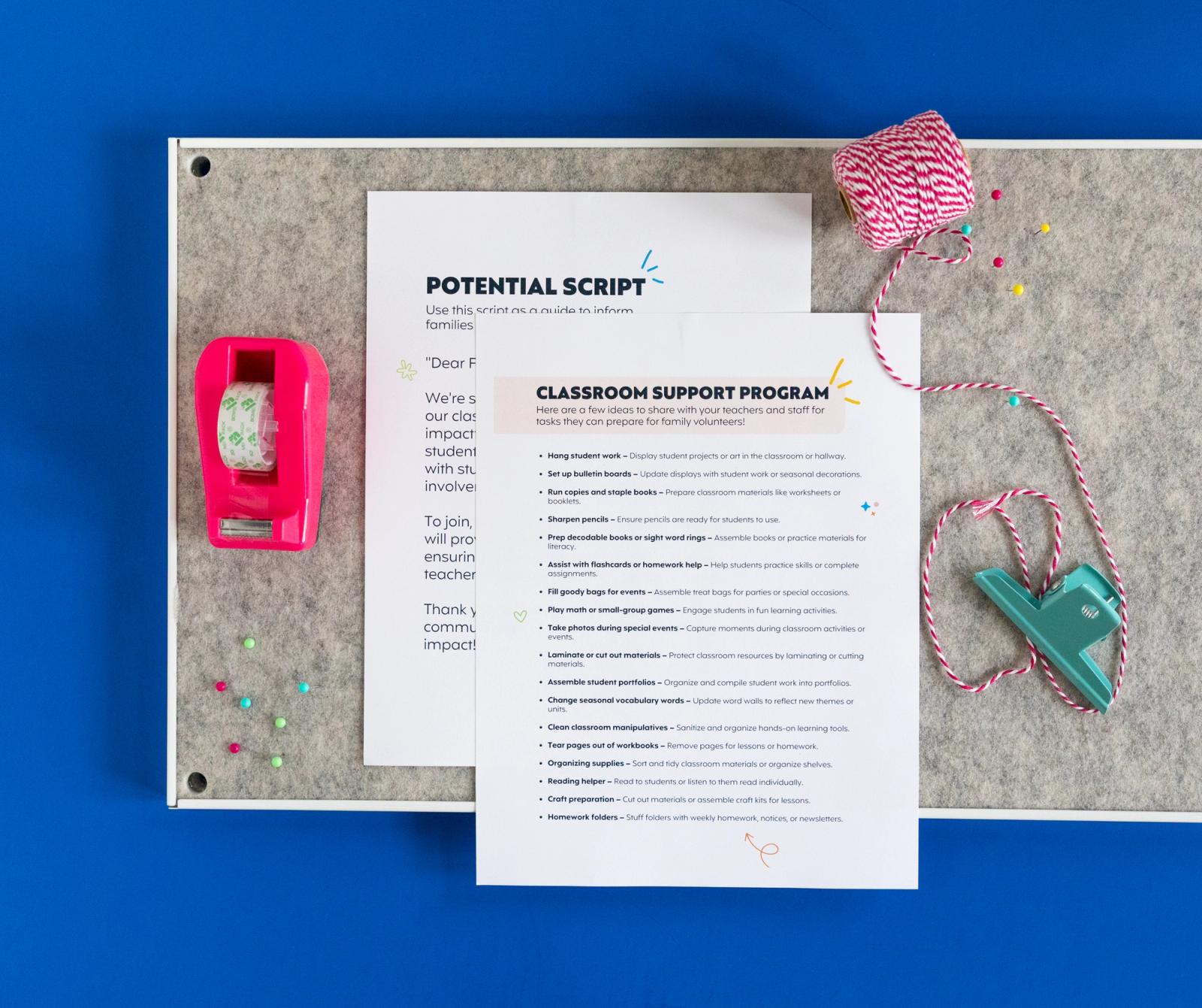 Two sheets of paper, tape dispenser, and string lay on a bulletin board on a dark blue background.