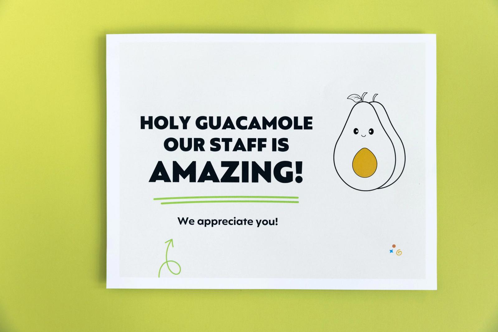 A paper that says "holy guacamole our staff is amazing" lays on a light green background.