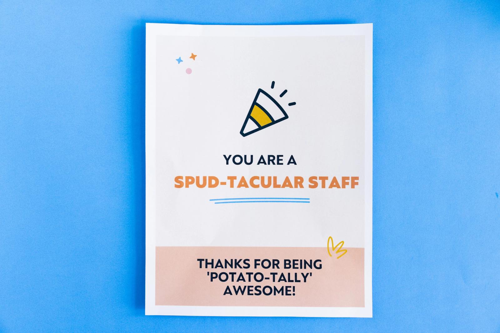 A poster that says "you are a spud-tacular staff" lays on a blue background.