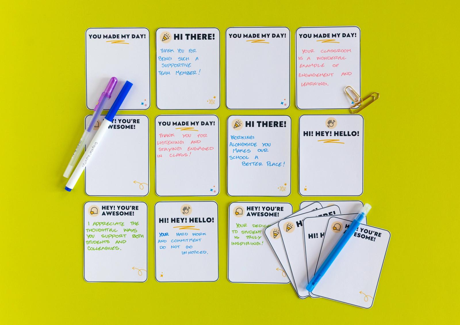 Twelve handwritten notes on a green background with pens scattered around them.