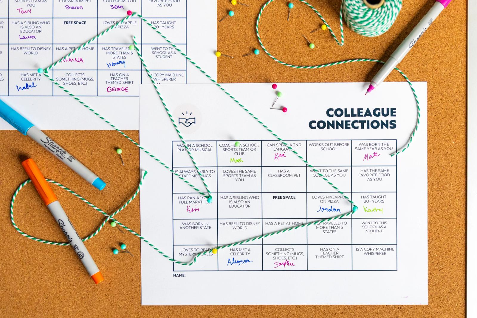Two pieces of paper pinned to a bulletin board with a grid printed on them. Green string connects squares from each paper. Colorful pens lay around the papers.