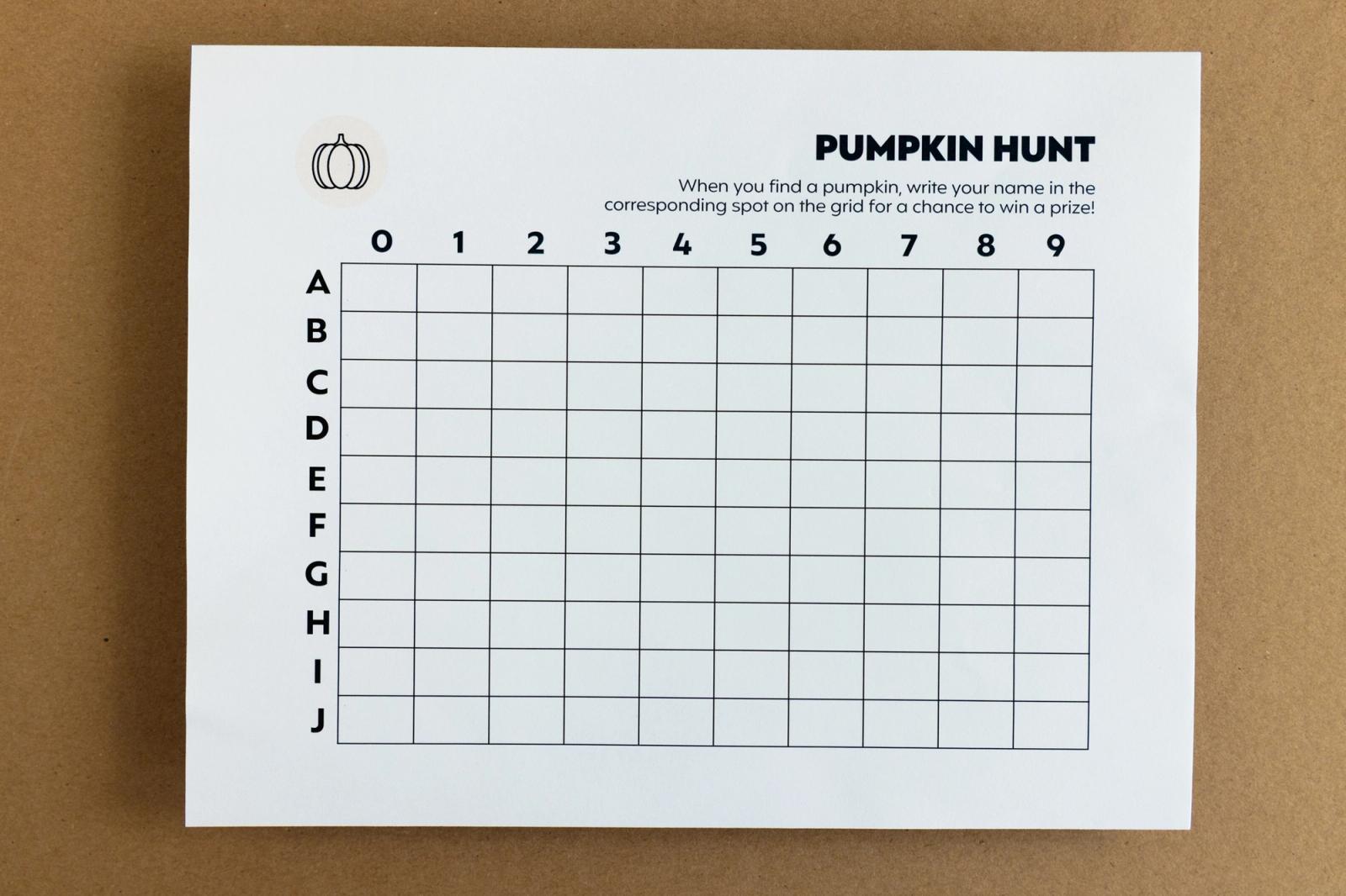 A piece of paper that says "pumpkin hunt" with a grid lays on a brown background.