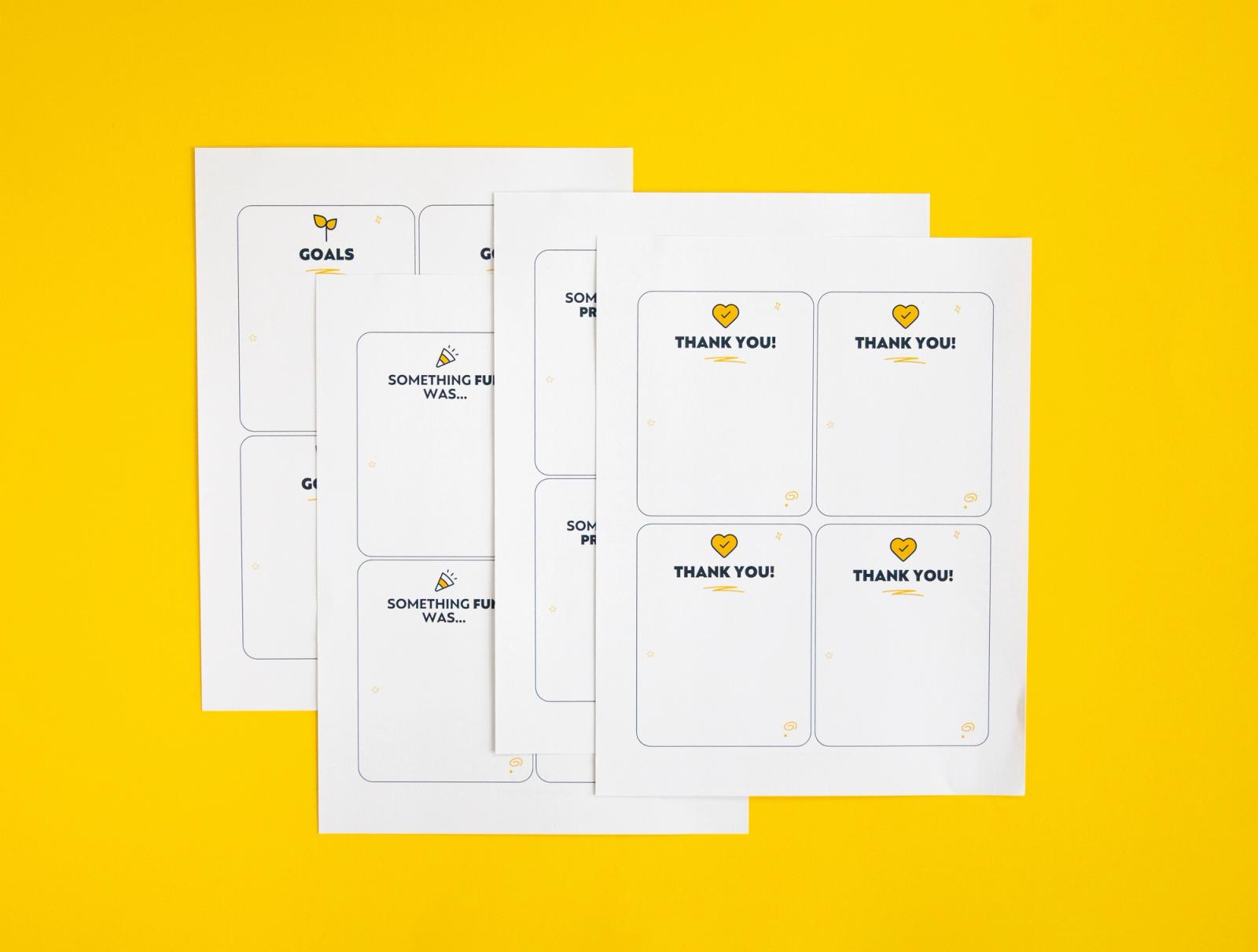 Four sheets with four notecards on them lay on a yellow background.