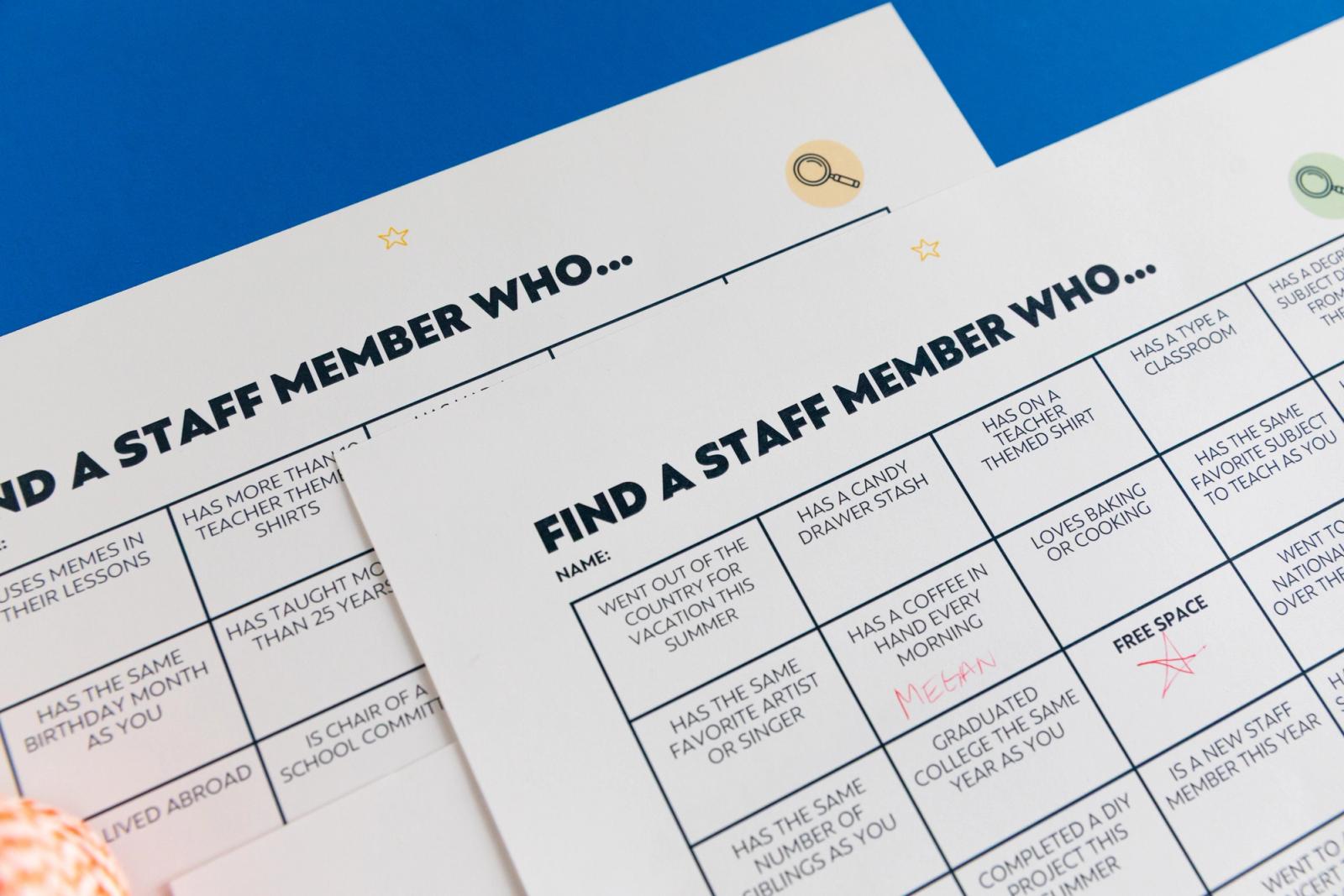 Close-up of two sheets of paper that say "find a staff member who" and have a bingo grid on them.