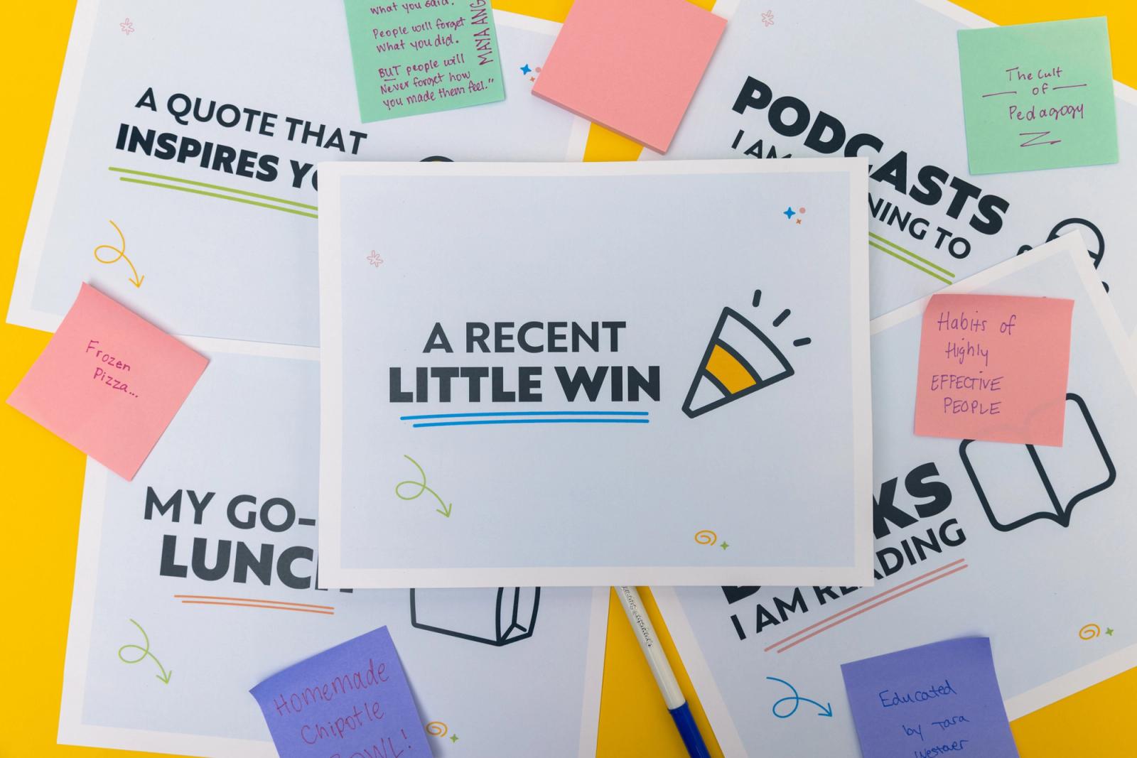 Several sheets of paper and sticky notes lay on a yellow background.