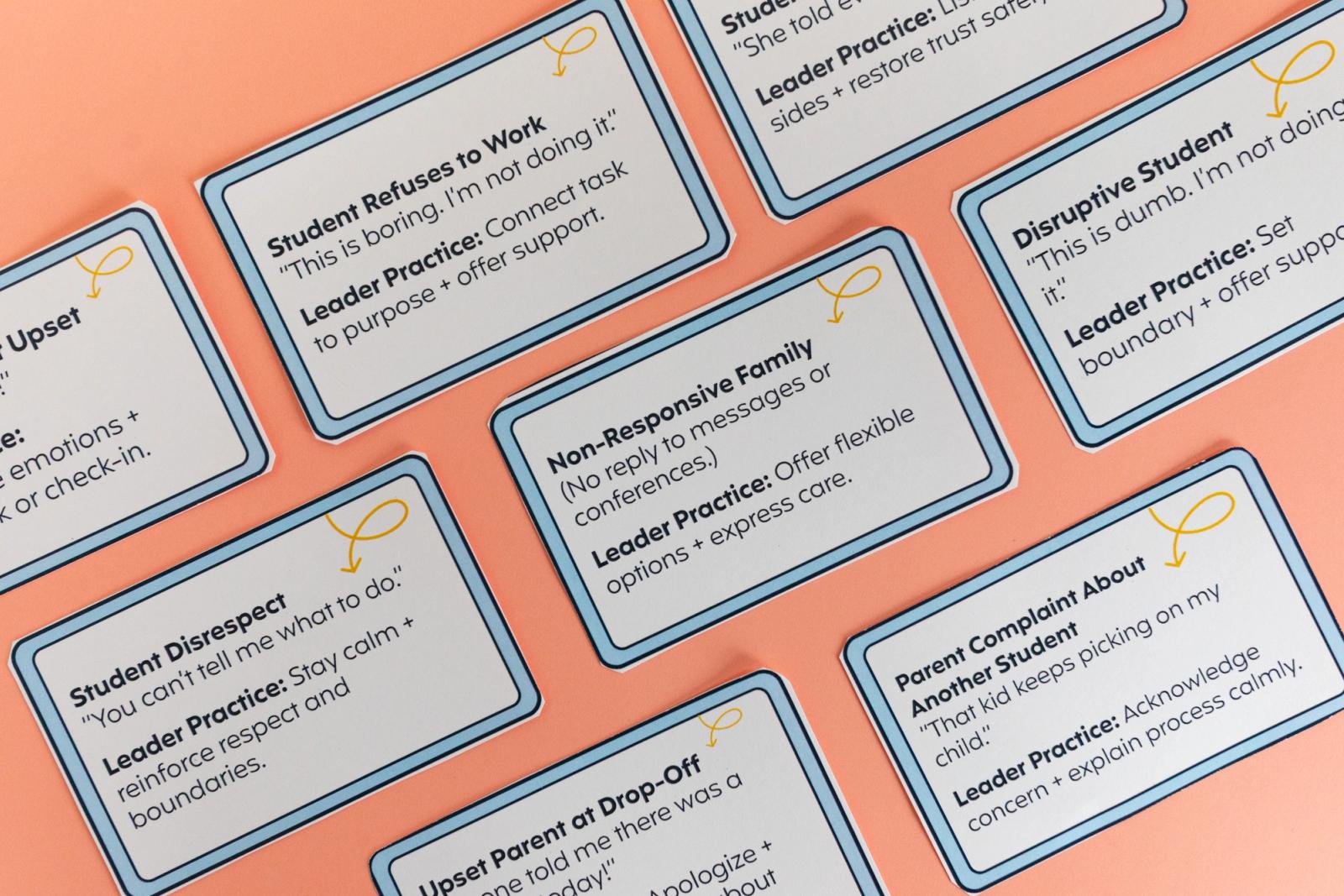Notecards typing on them lay diagonally on a salmon background. 