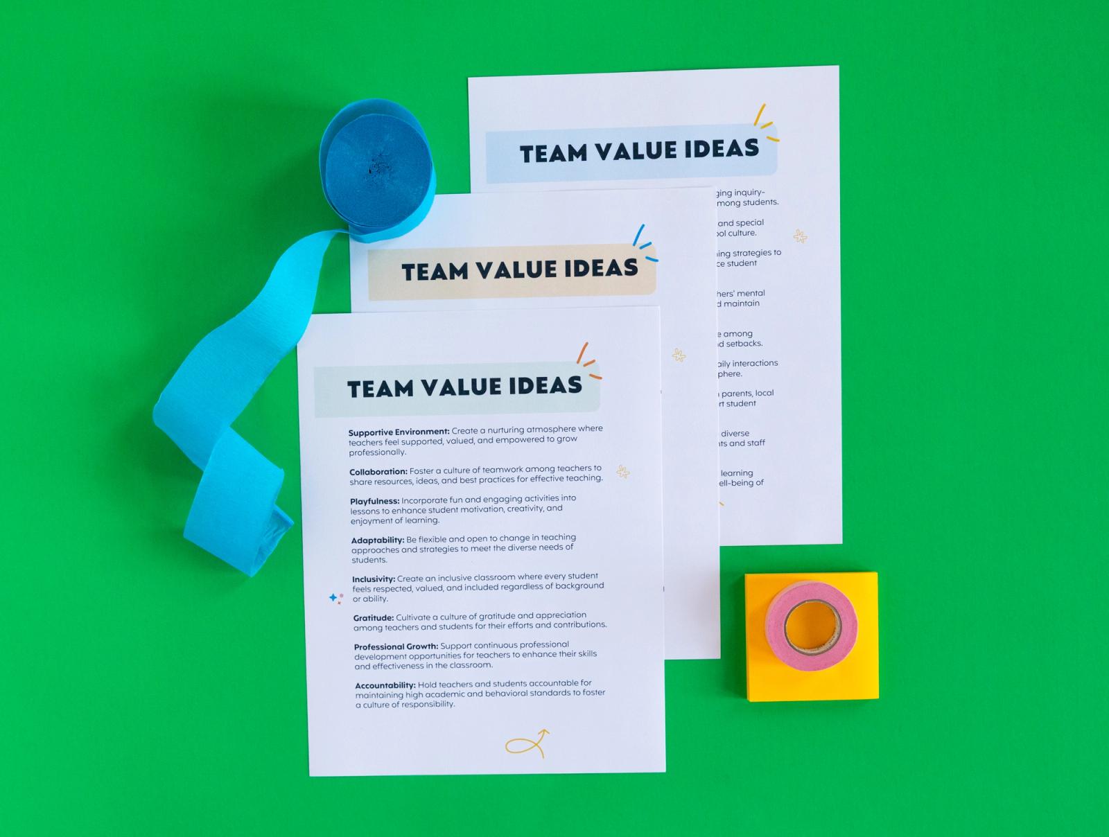 Three sheets of paper that say "team value ideas" streamers, sticky notes, and tape lay on a green background.