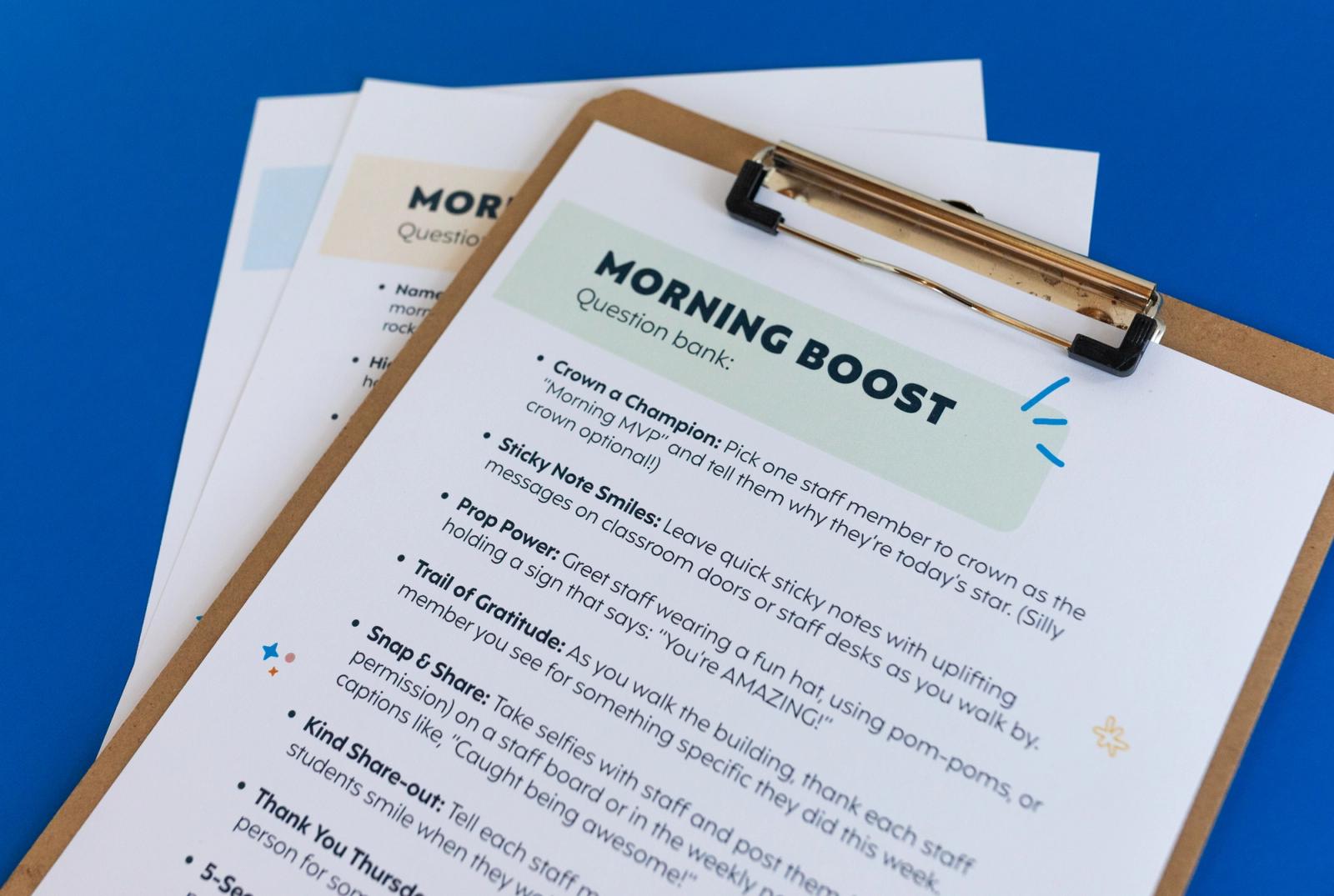 Closeup of a piece of paper that says "morning boost" on a clipboard on a blue background.