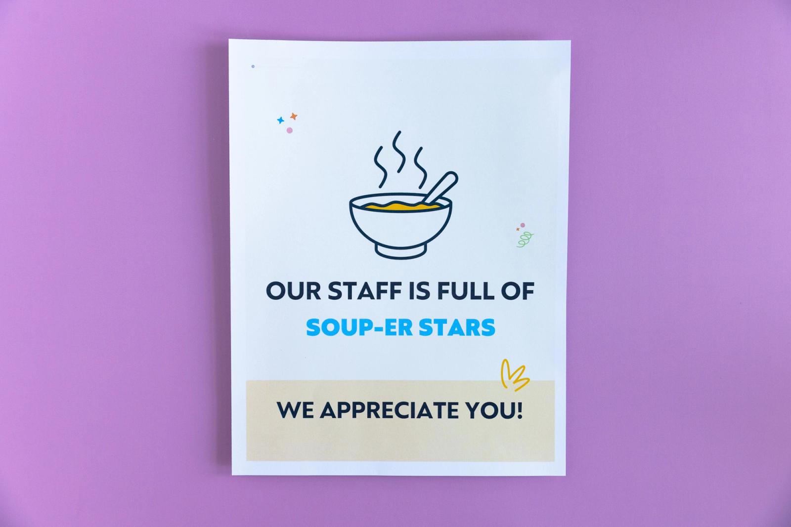 A sheet of paper that says "our staff is full of soup-er stars" lays on a light purple background.