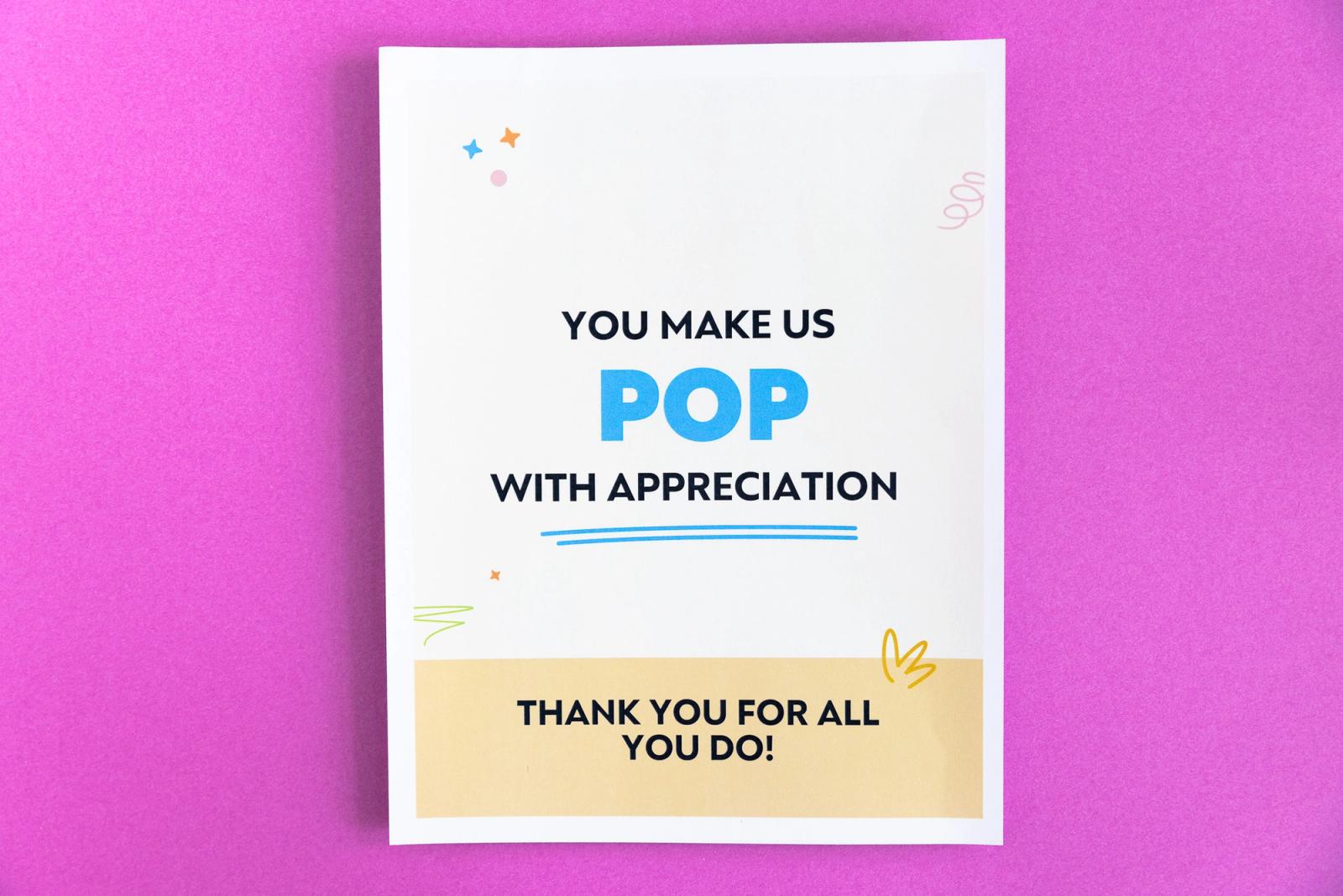 A poster that says "you make us pop with appreciation" lays on a magenta background.