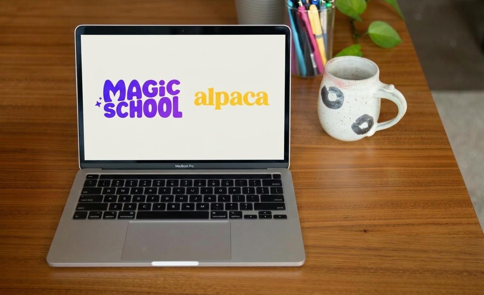 A laptop with logos for MagicSchool and Alpaca on the screen sits on a wood desk with a coffee cup and jar of pens.