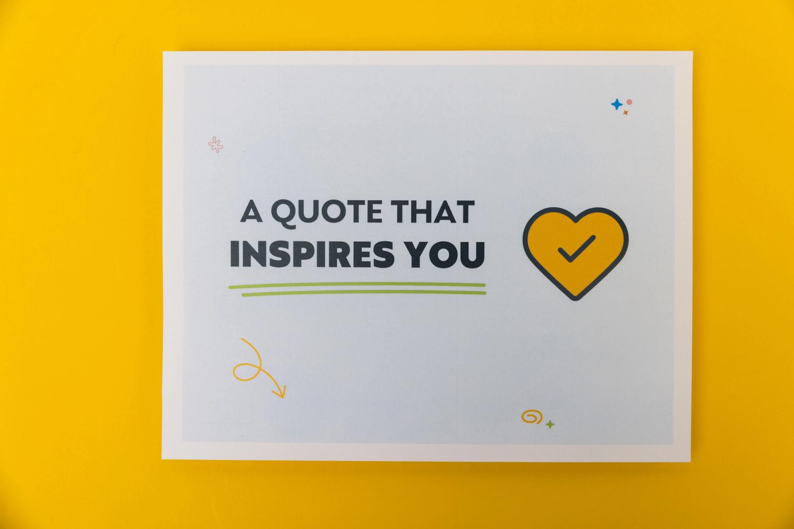A piece of paper that says "a quote that inspires you" lays on a yellow background.
