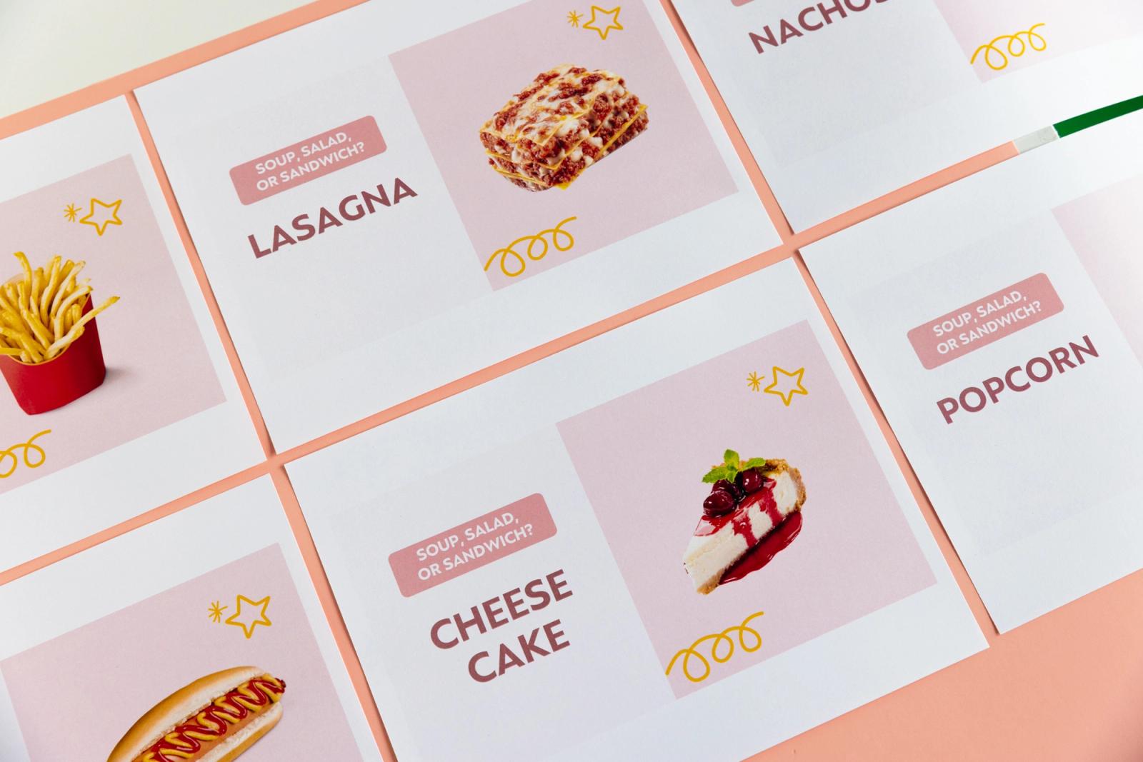 Papers with images of food on them lay on a peach background.