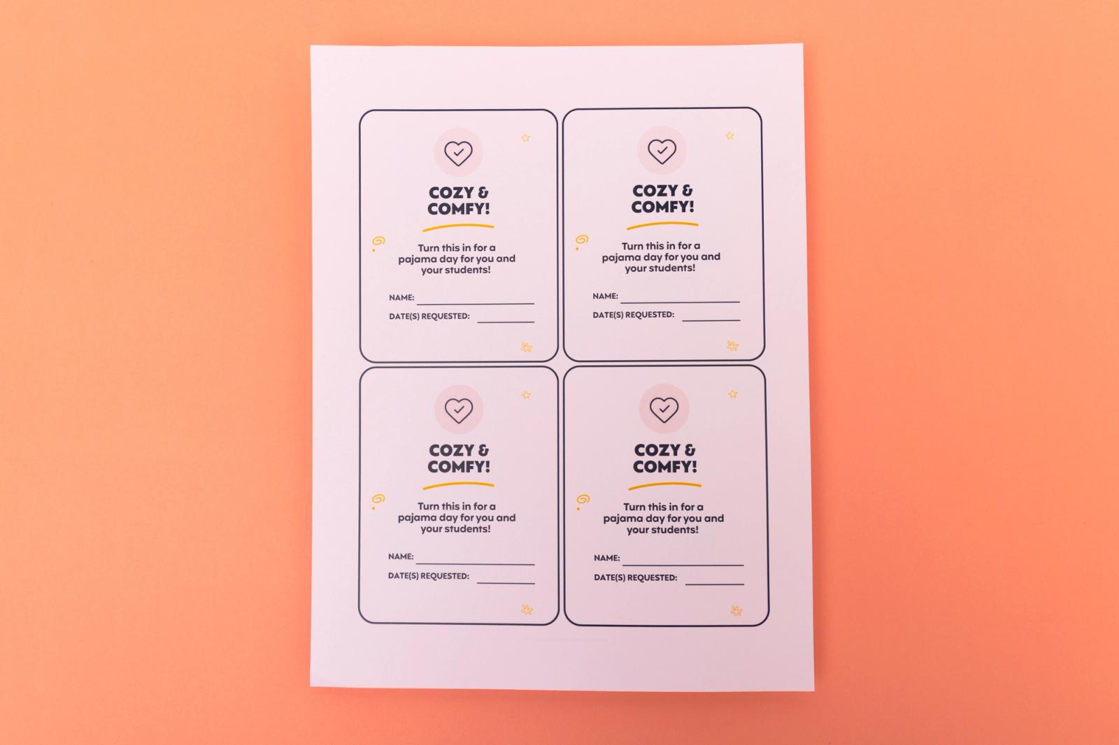 A sheet of paper with four coupon cutouts that say "cozy and comfy" lay on a pin background.