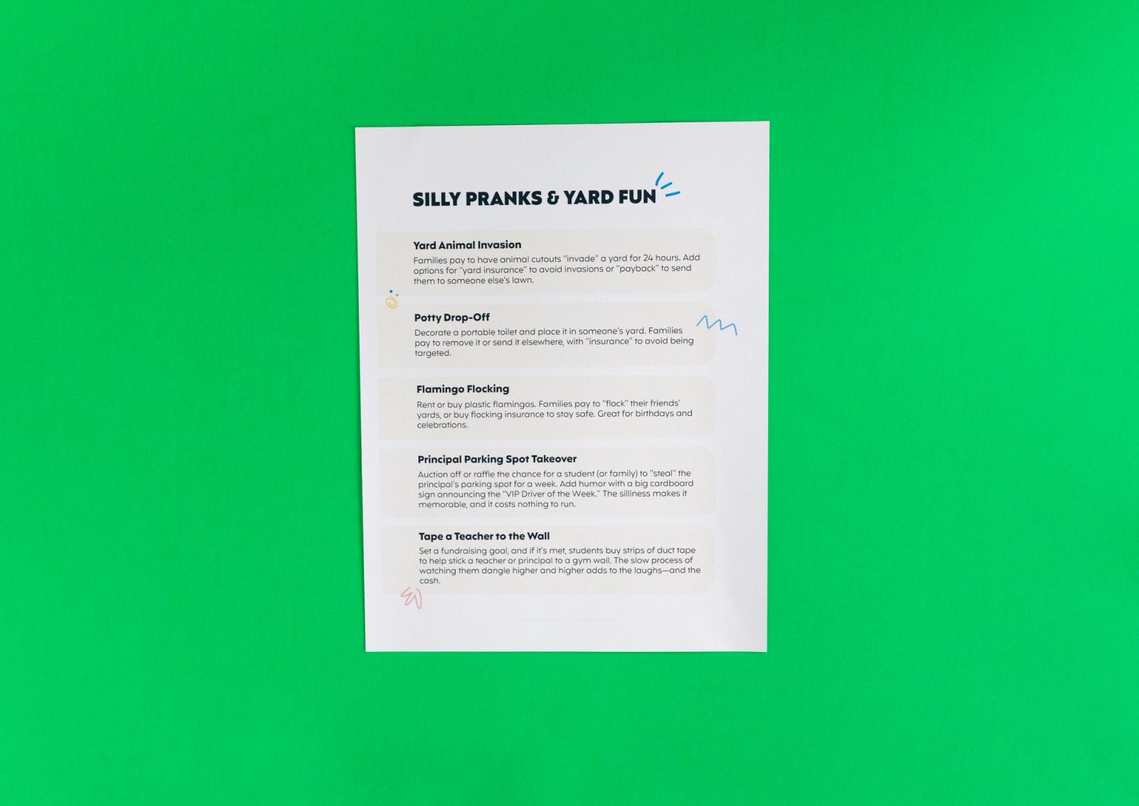 Sheet of paper that says "silly pranks and yard fun" on it lay on a green background.
