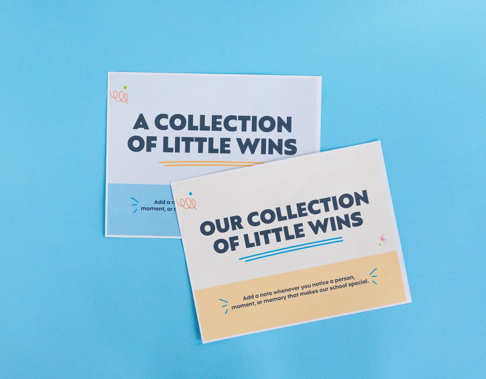 Two sheets of paper that say "a collection of little wins" lay on a light blue background.
