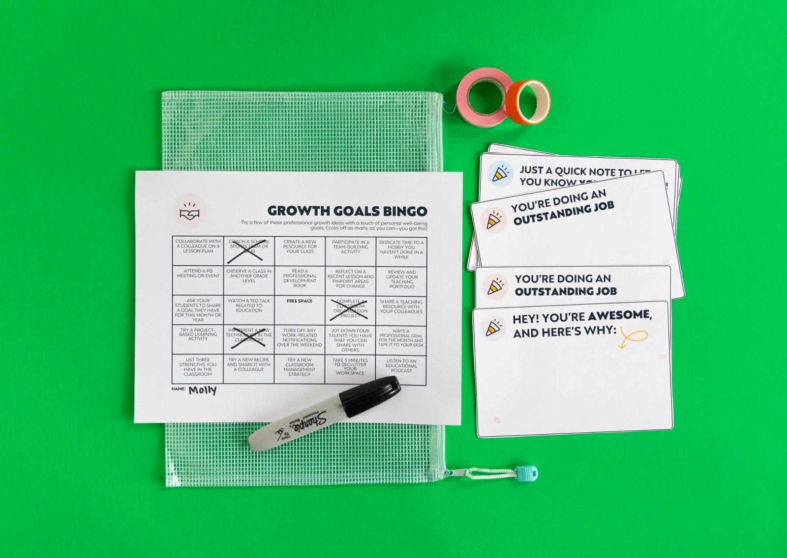 A sheet with a bingo card with three spots X'd out sits on a bright green background. Beside it are blank notecards, a black marker, and roll of tape.