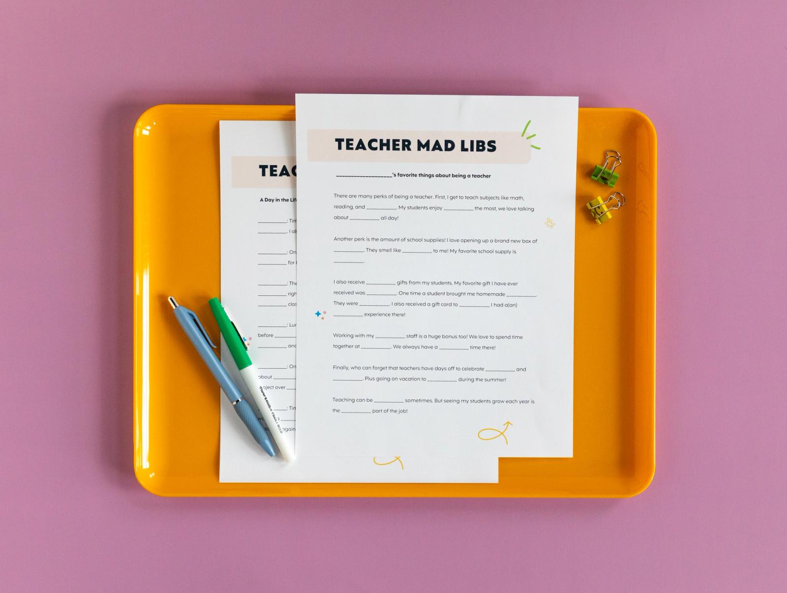 Two sheets of paper and pens lay on an orange tray on a light purple background.