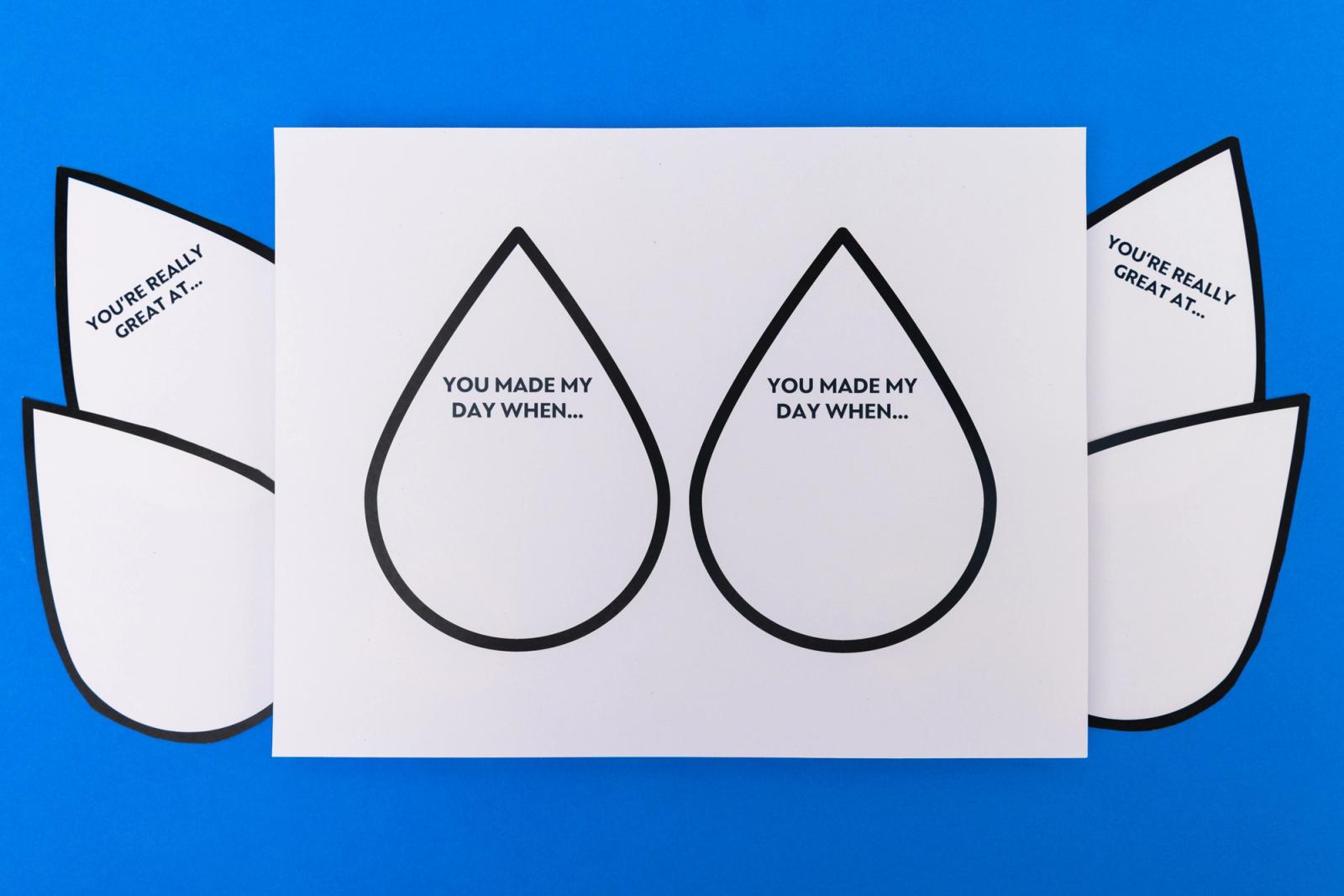 A sheet of paper that has water droplet cutouts on it lays on a blue background.