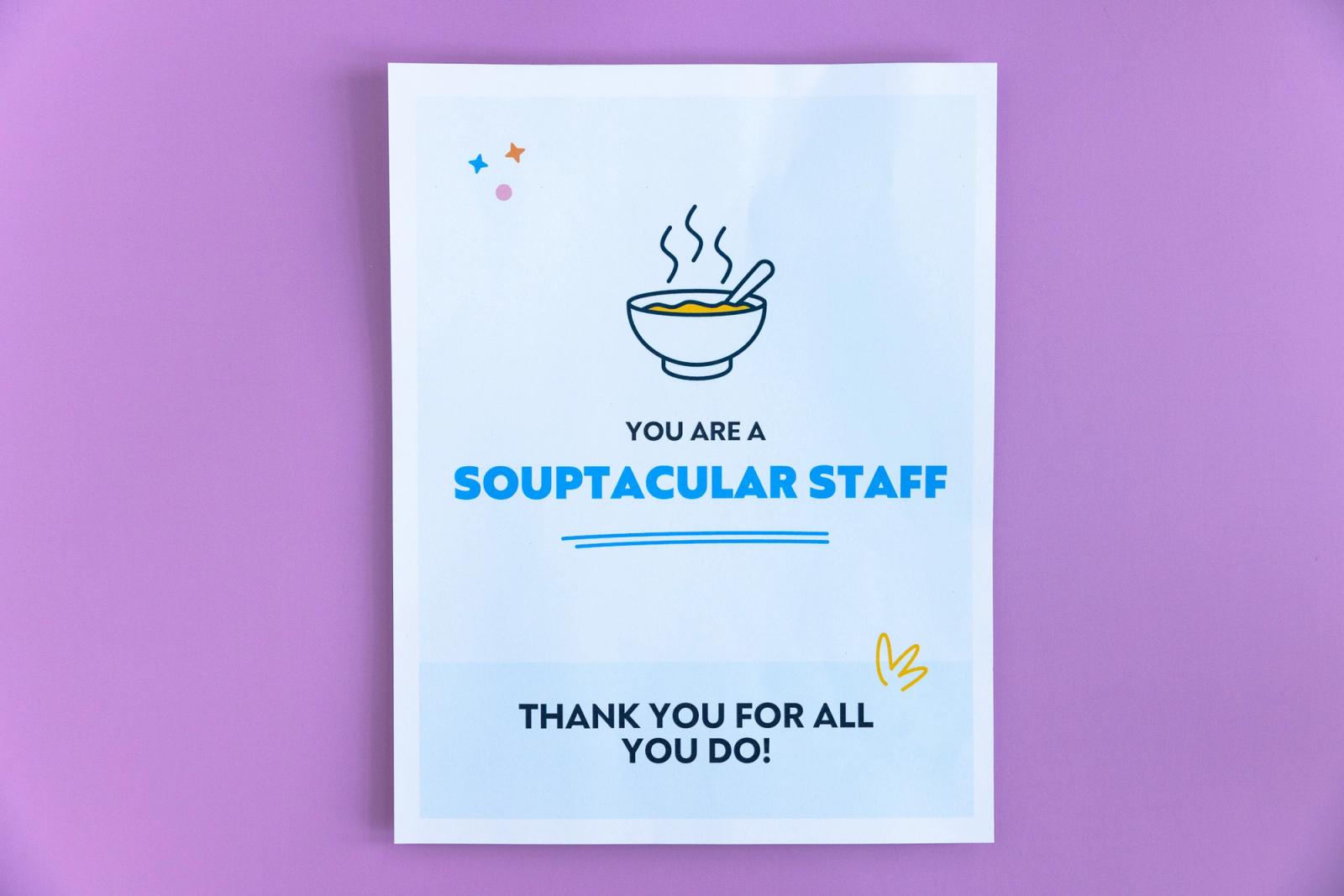 A sheet of paper that says "you are a souptacular staff" lays on a light purple background.
