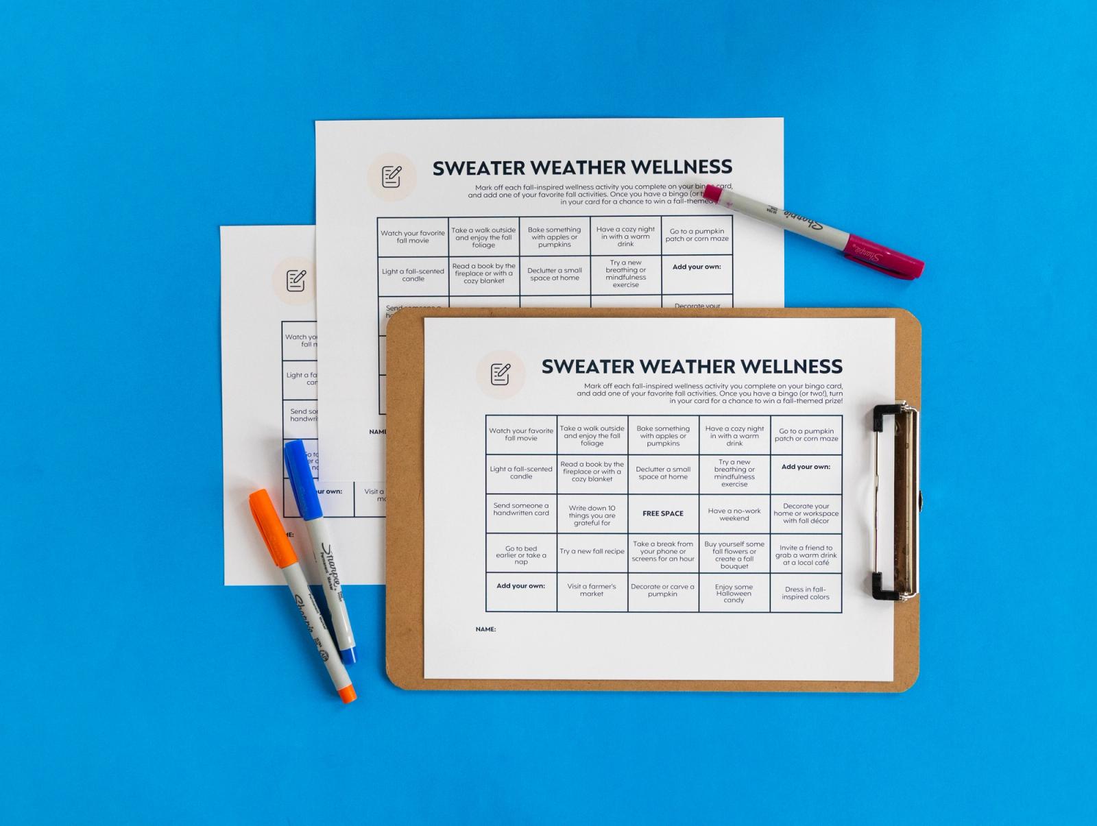 Sheets of paper, clipboard, and markers lay on a blue background.