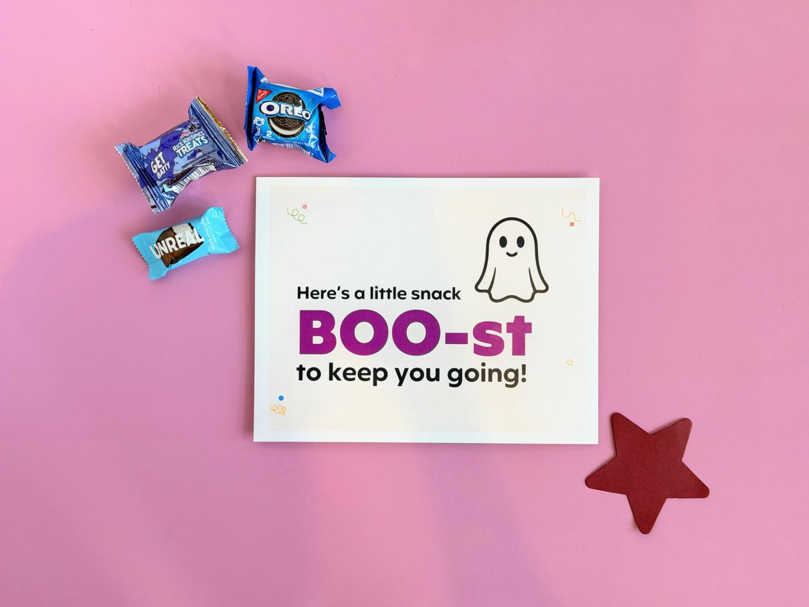 “Snack BOO-st” Halloween treat station sign with a ghost, wrapped cookies, a crispy rice treat, and a chocolate bar