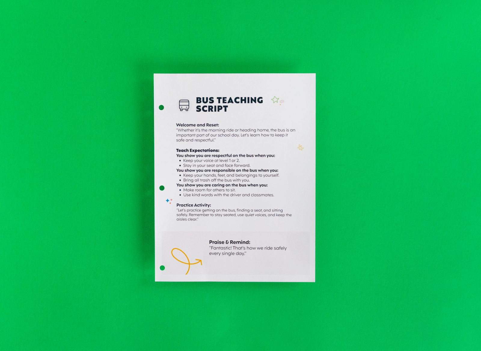 A sheet of paper that says "bus teaching script" on it lays on a green background.